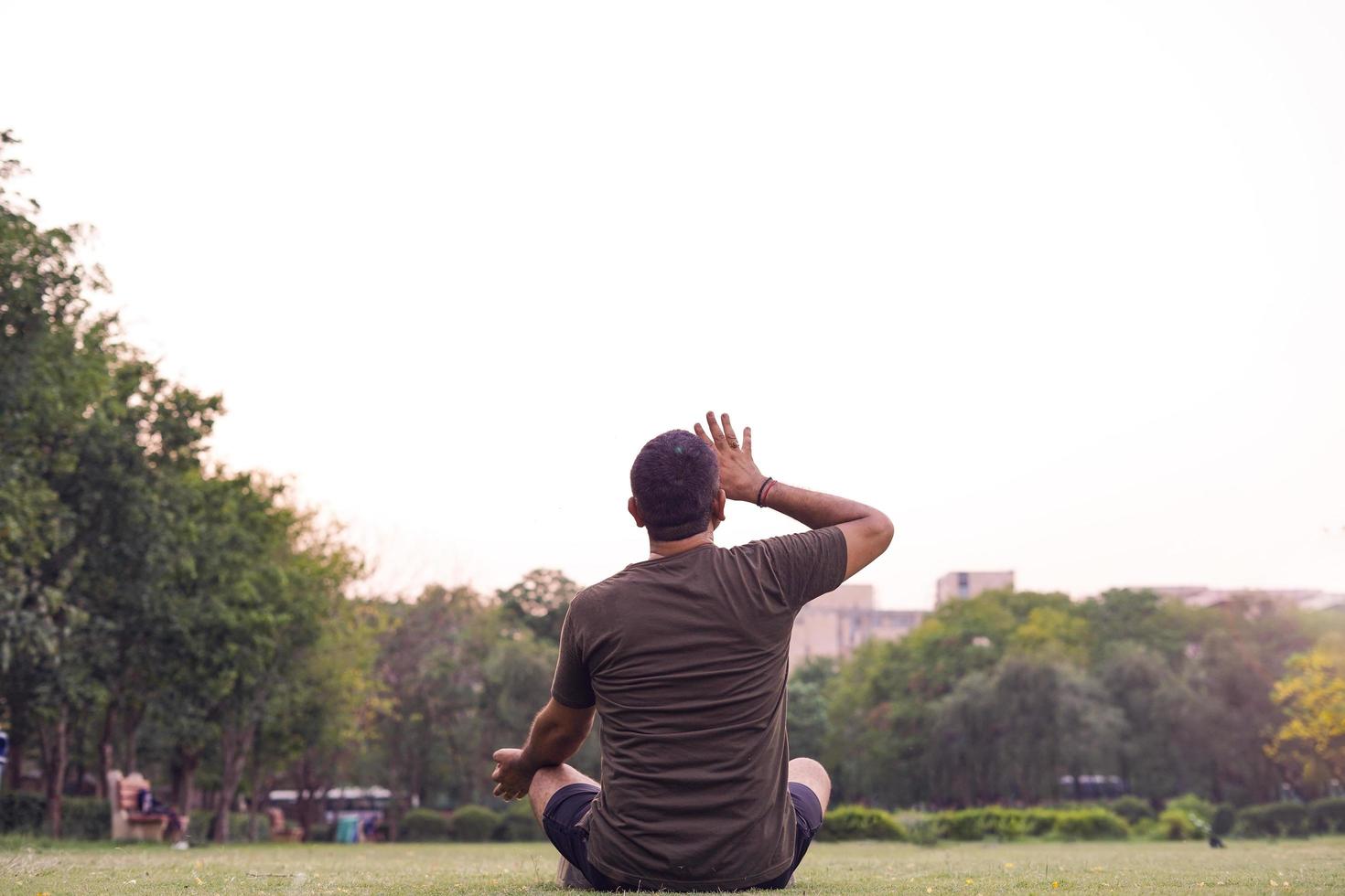 Hombre haciendo yoga en un parque. foto