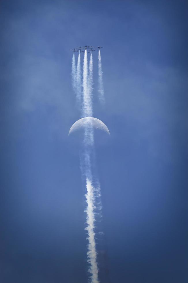 Airplanes flying in formation with moon in background photo