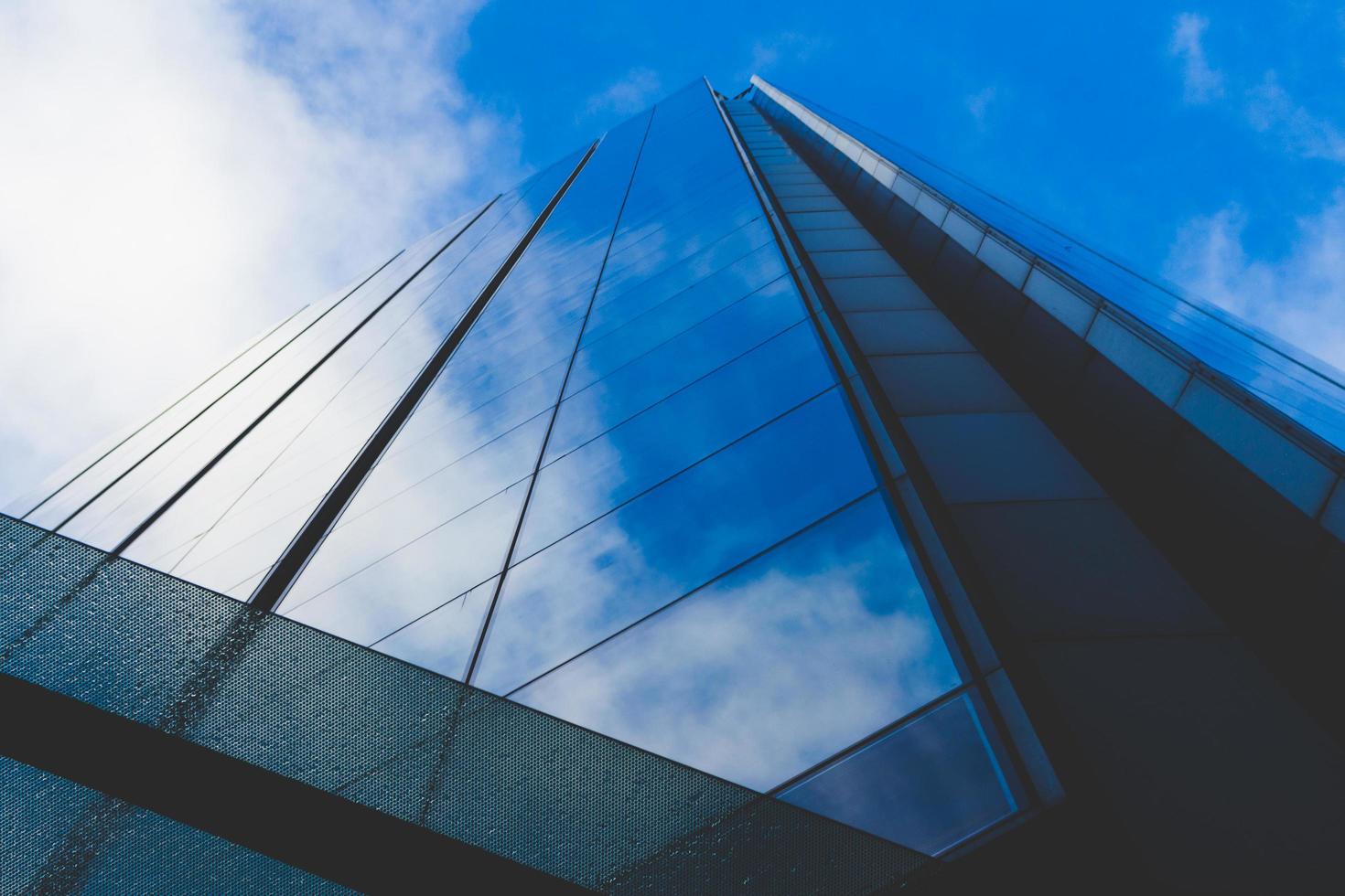 Clouds and blue sky reflected in building windows photo