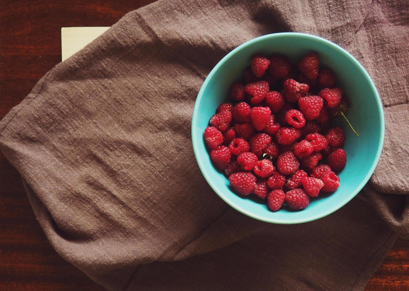 Raspberries in bowl with cloth photo