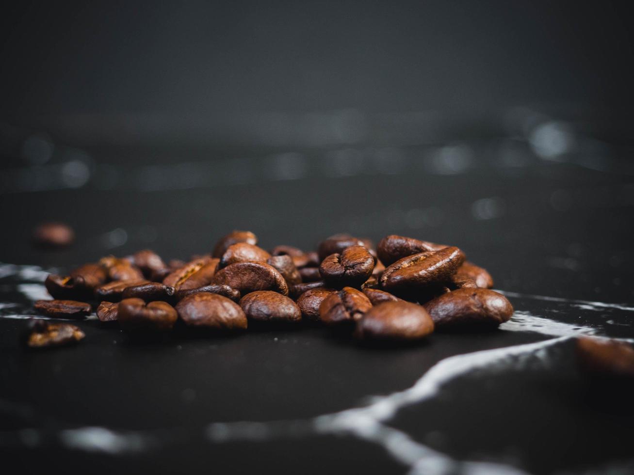 granos de café en superficie de mármol negro foto