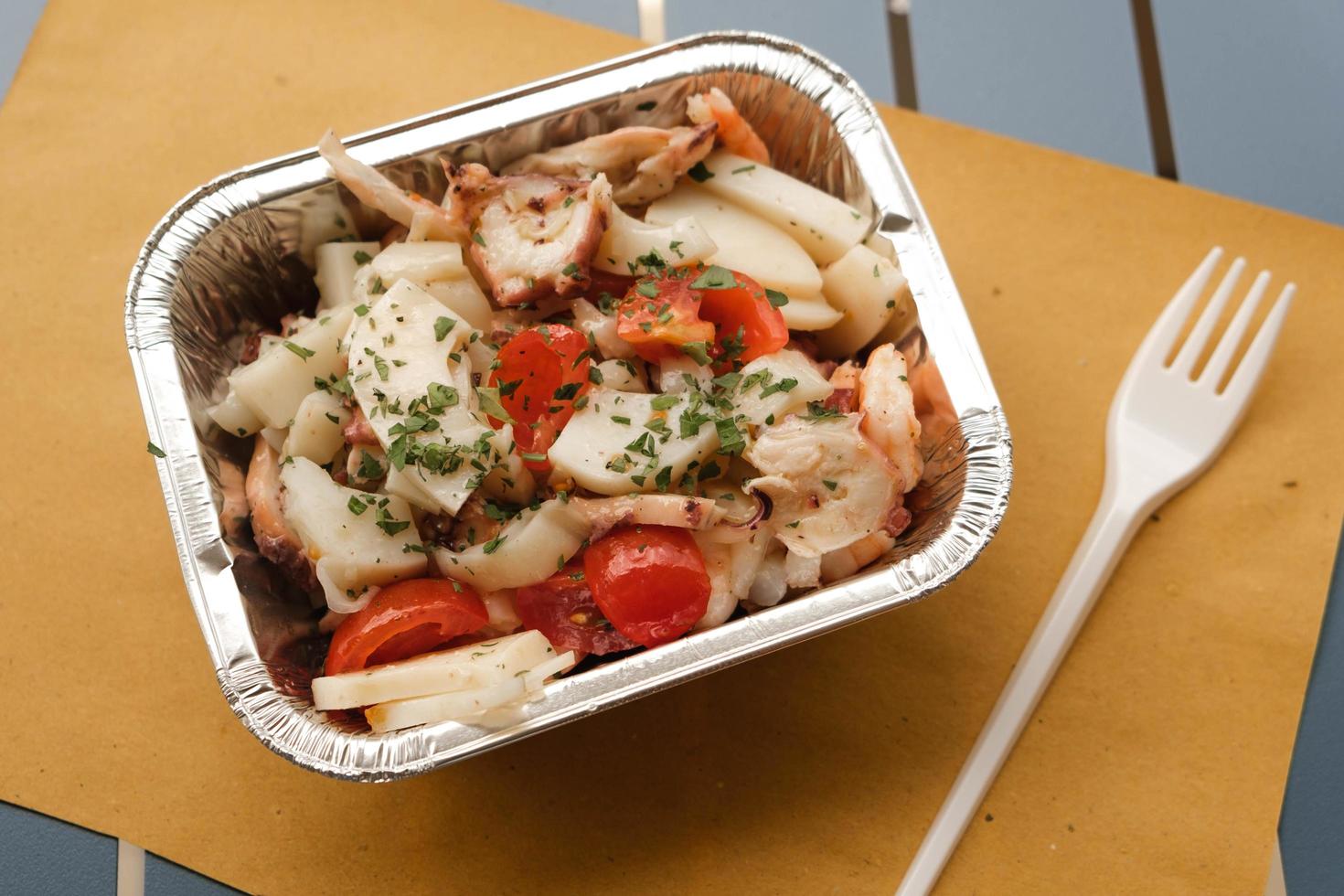 ensalada de mariscos en recipiente de papel de aluminio foto