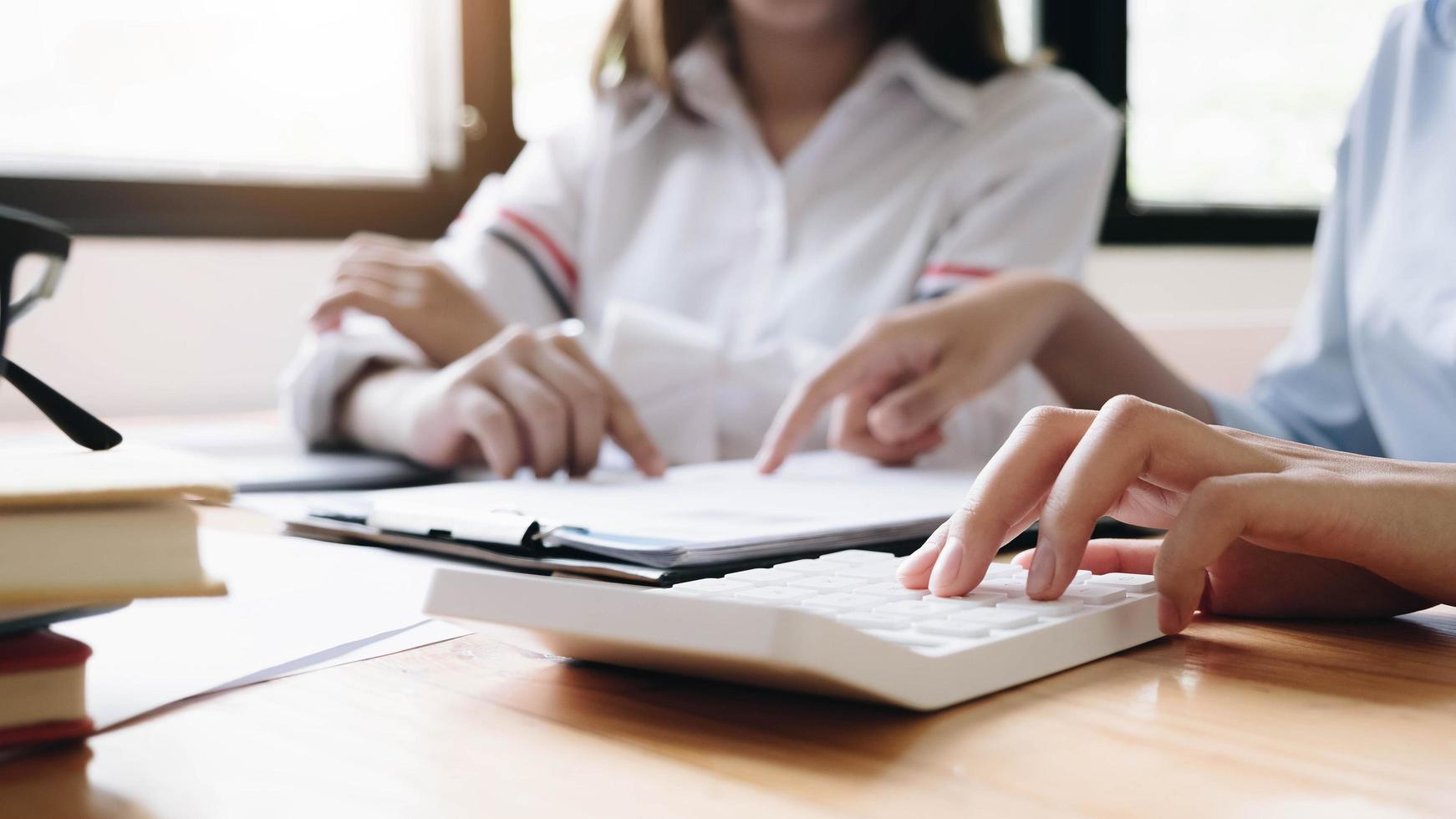 Two businesswomen using calculator photo