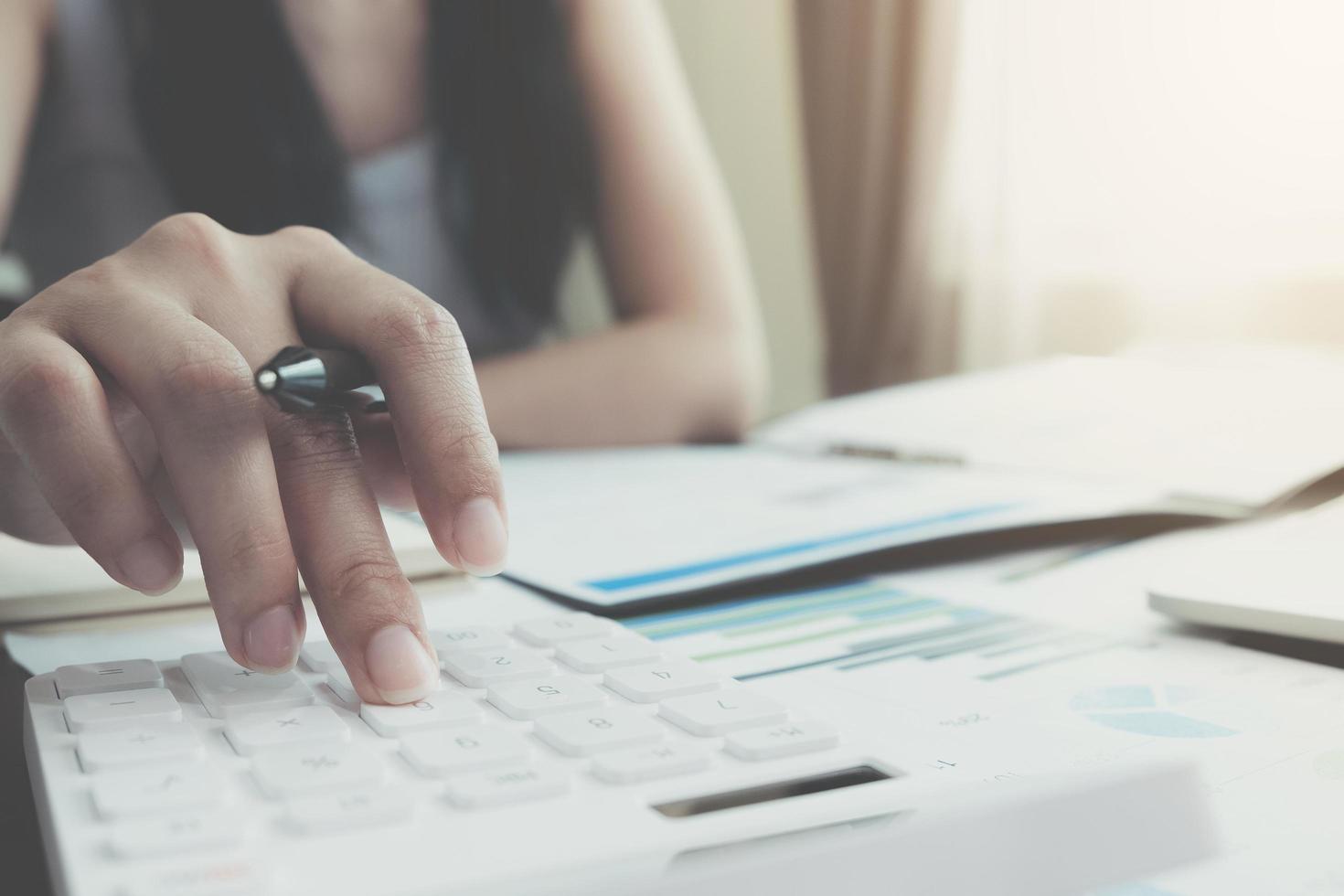 Close-up of woman using calculator photo