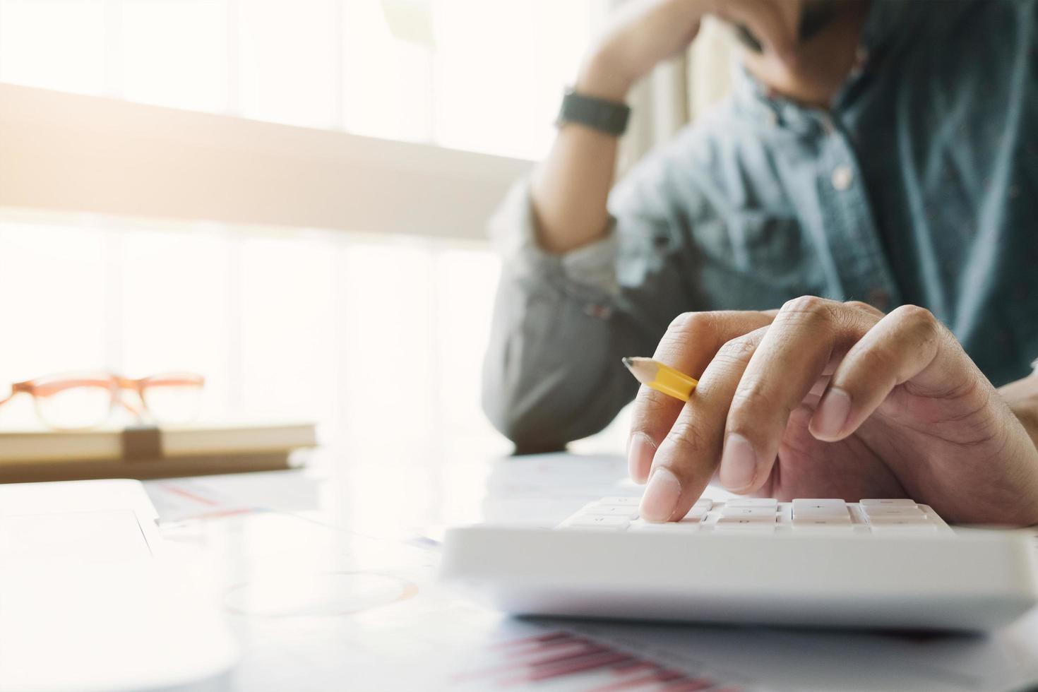 primer plano del empresario trabajando en calculadora foto