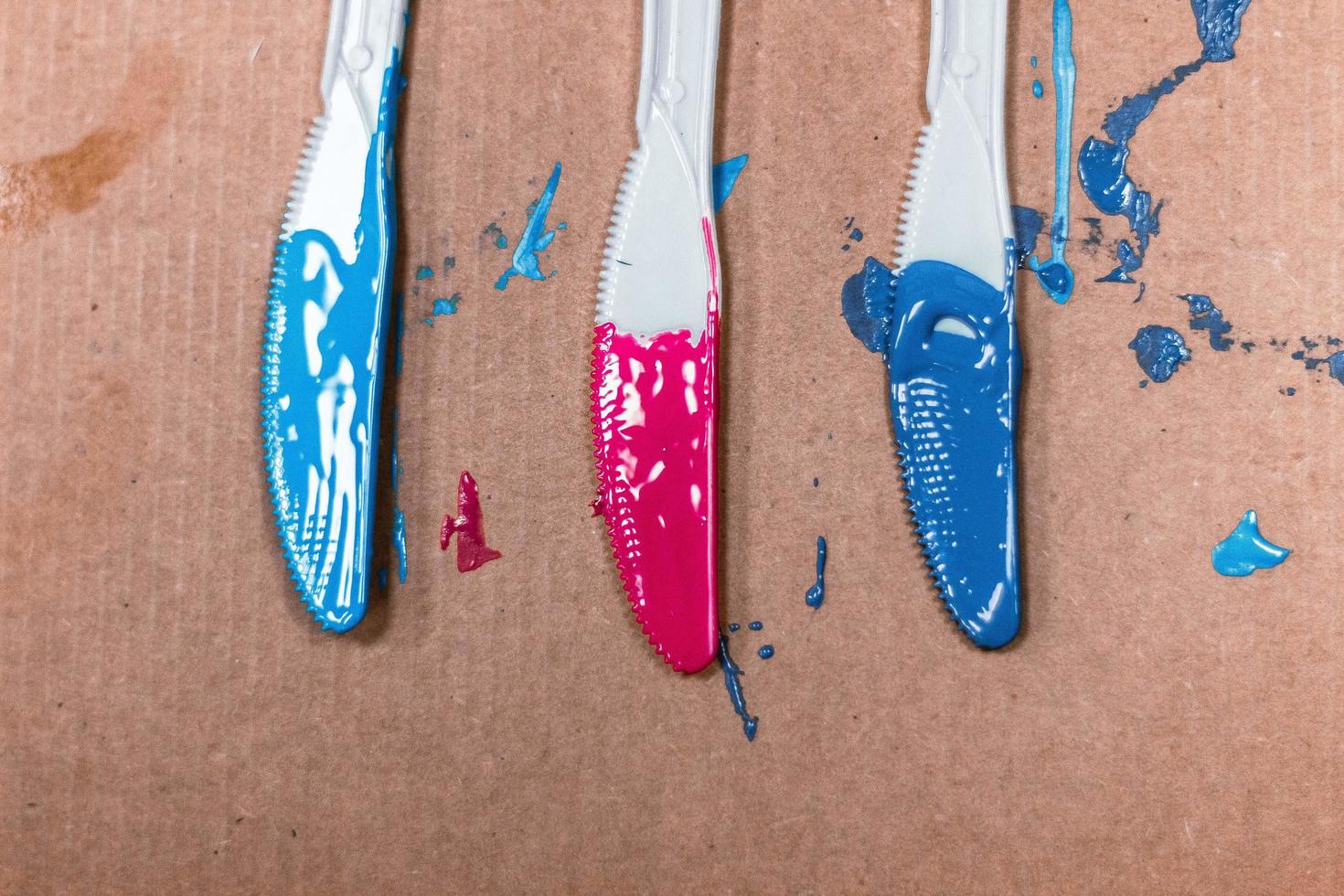 Acrylic paints applied on three plastic knives photo