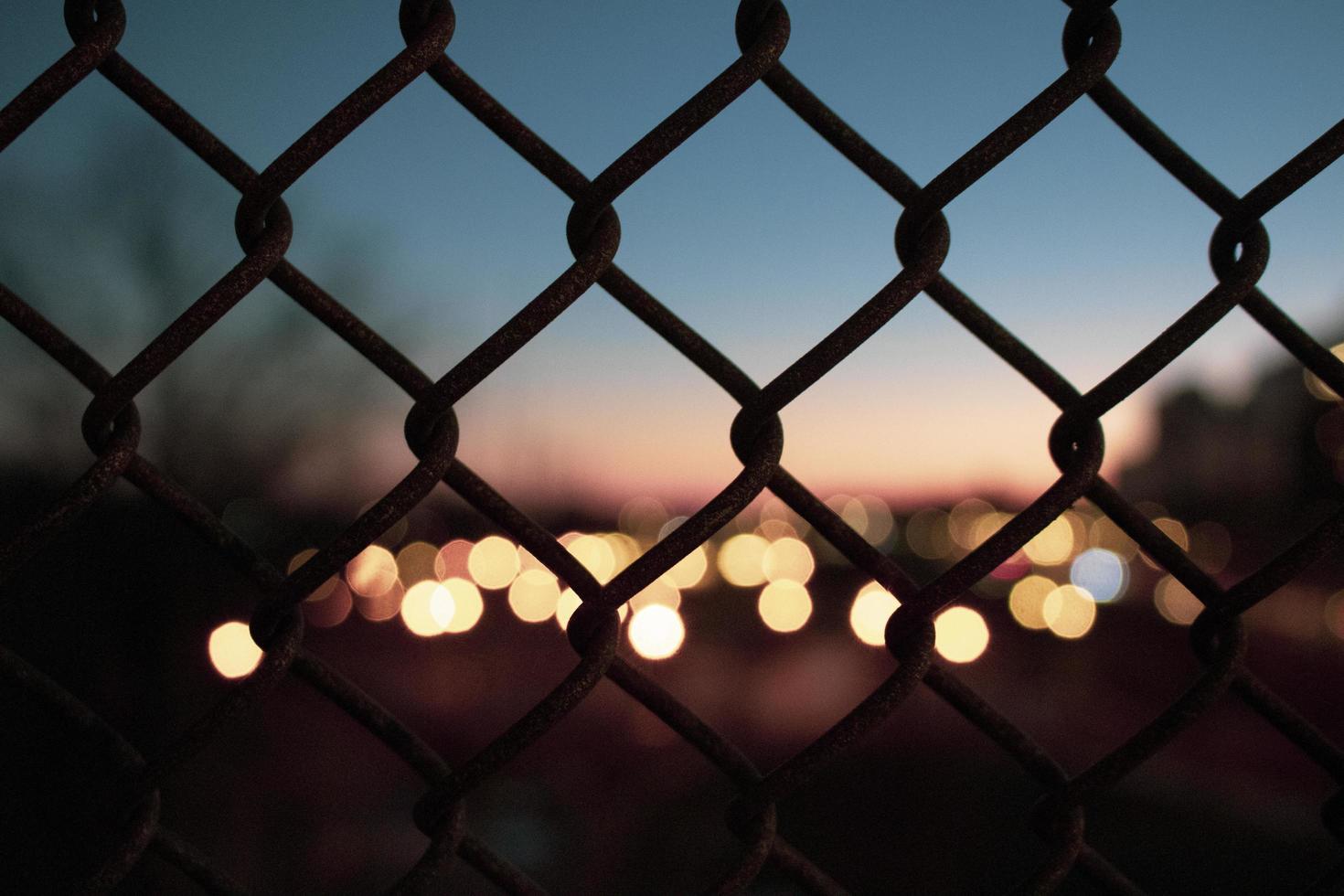 silueta de valla y luces de la ciudad, fuera de foco foto