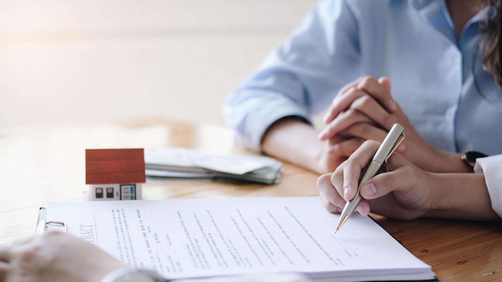 Real estate agent and customer signing contract photo