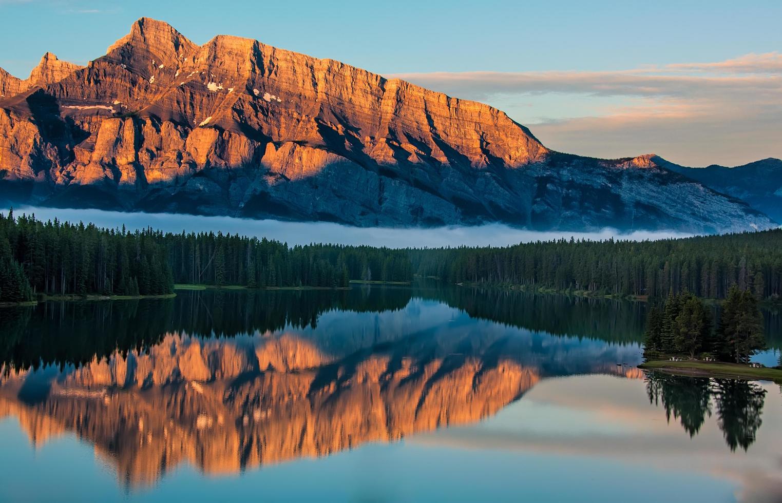 Mountains by body of water at sunset photo