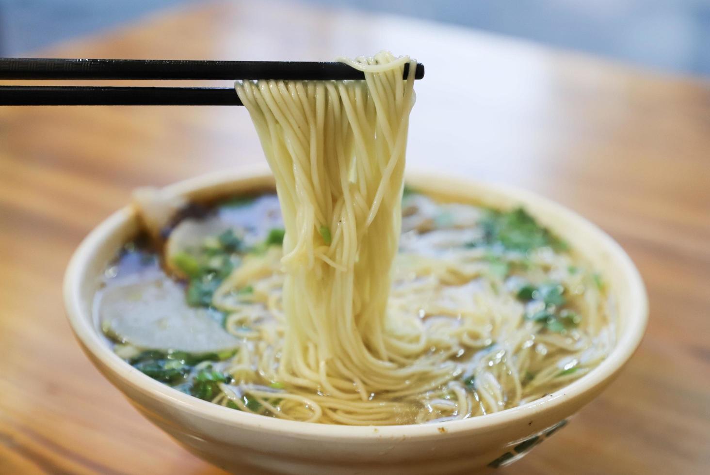 Close-up of chop sticks and bowl of ramen photo