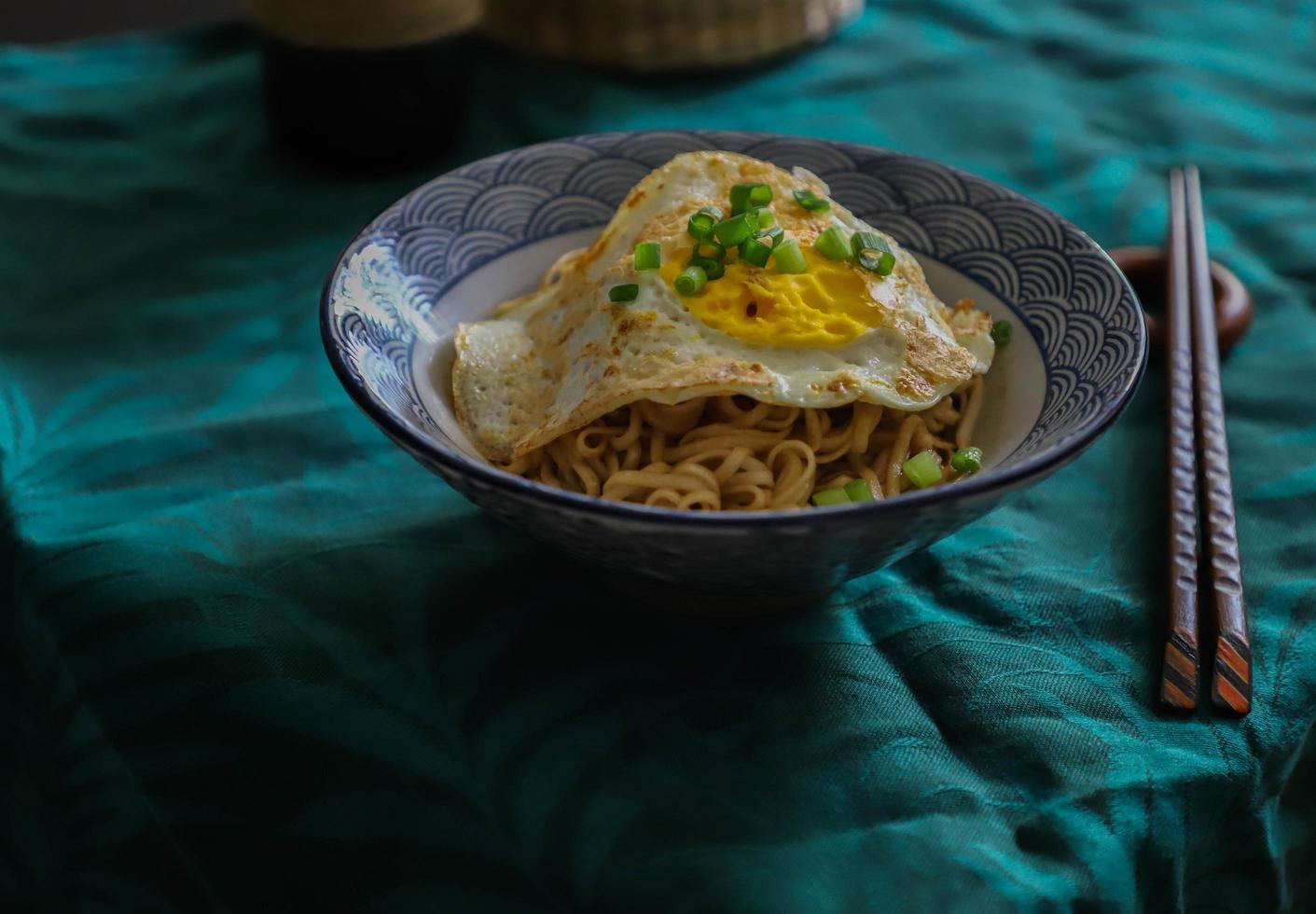 Bowl of noodles with fried egg photo