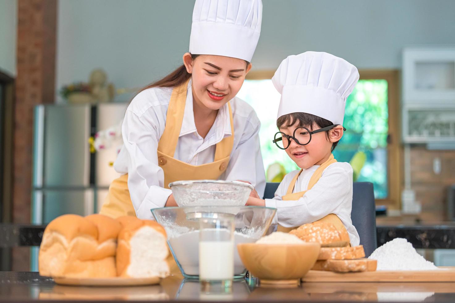 Asian boy and mother baking together photo