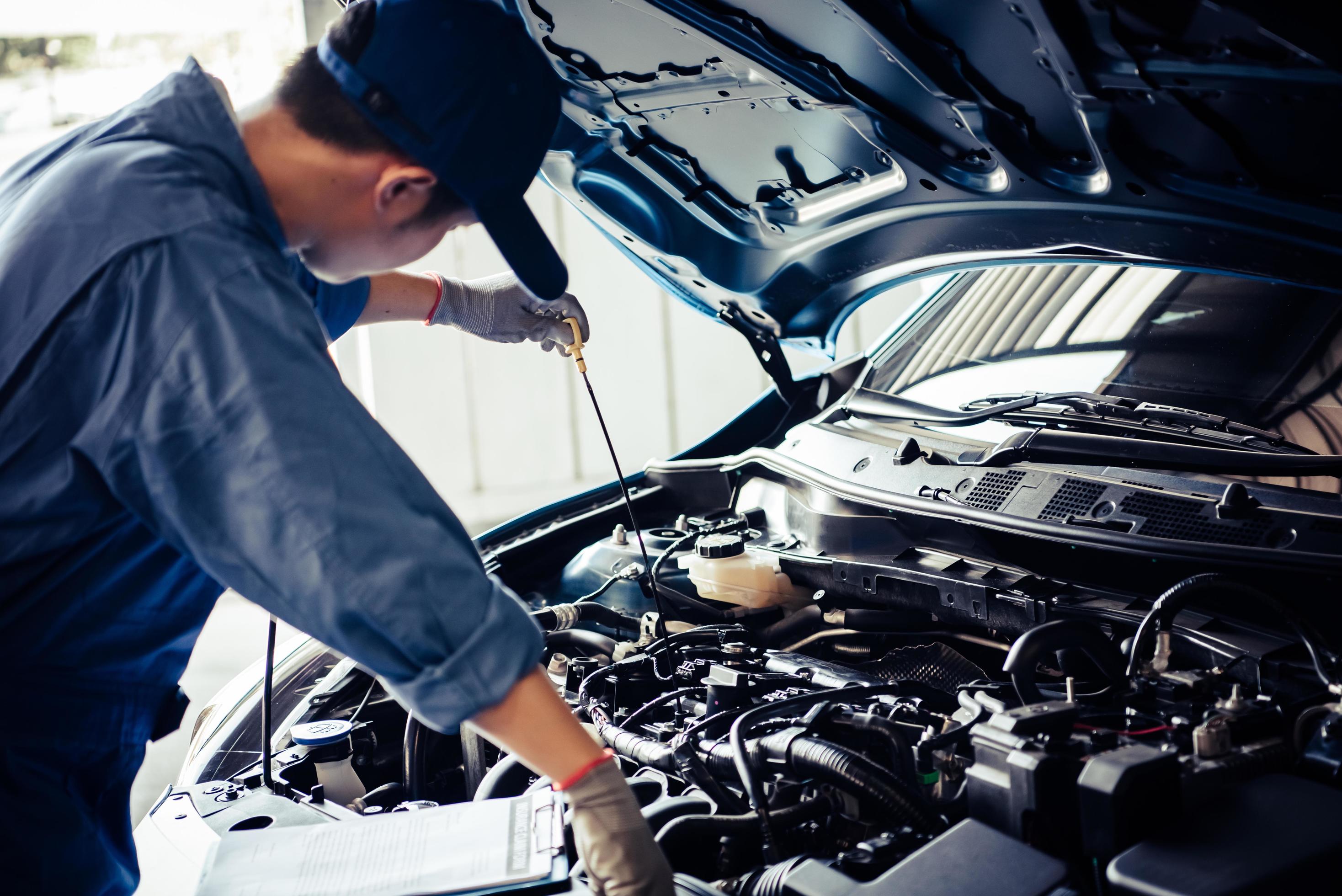 Car mechanic is conducting an inspection on vehicle Stock Photo
