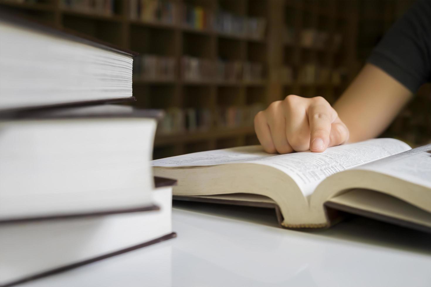 Cerca de una persona leyendo en una biblioteca foto