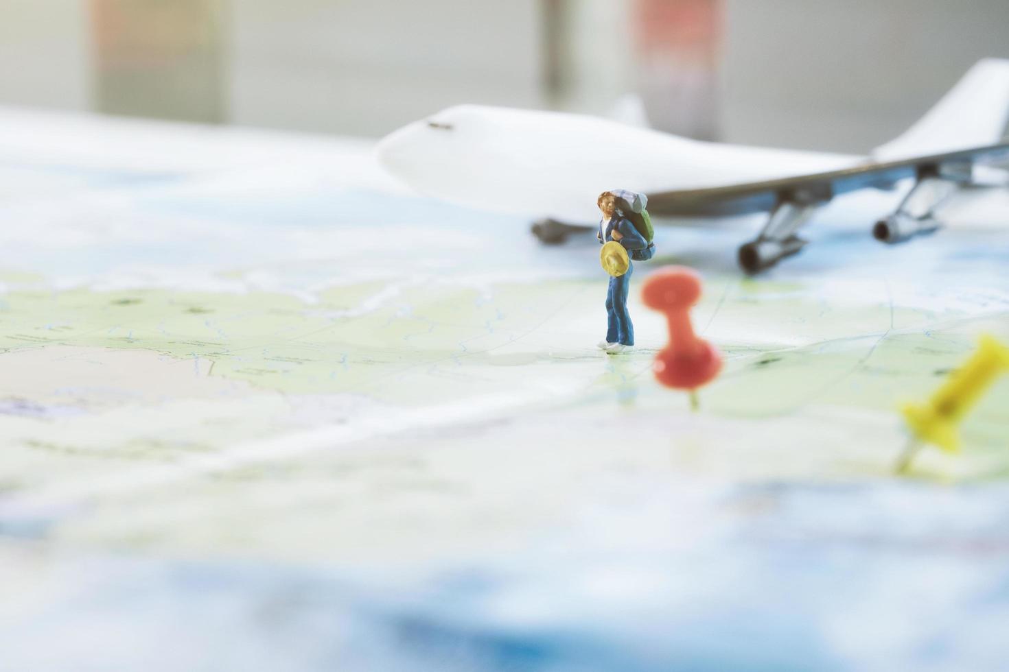 Figura de madera en miniatura de mochileros en el mapa de tamaño completo foto