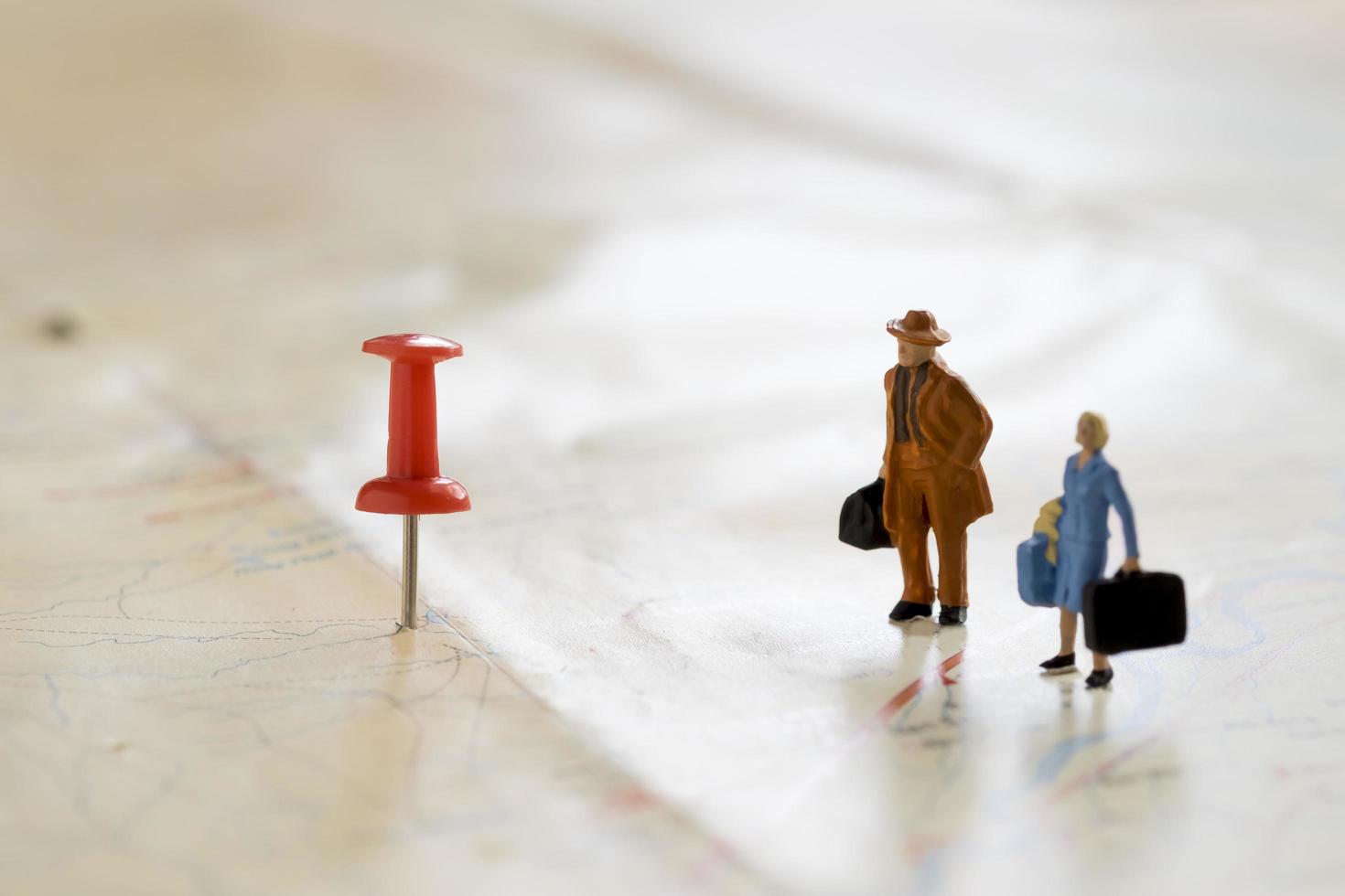 Small wooden human figurines stand on a map photo