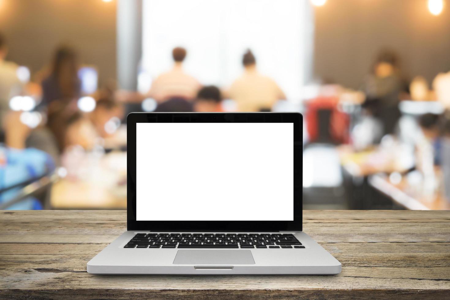 Open laptop on wooden desk in classroom photo