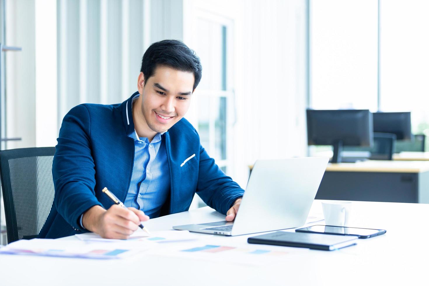 Young Asian businessman working at his desk photo