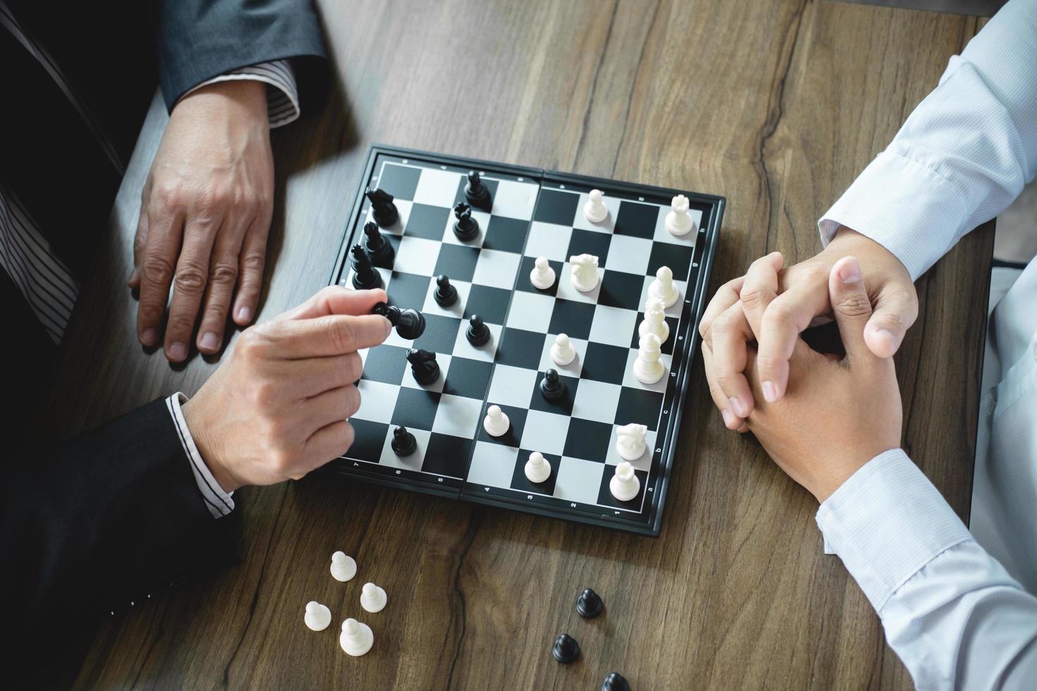 Confident businessmen playing chess game photo