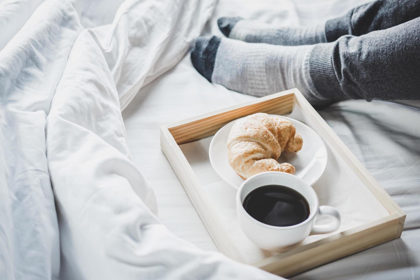 mujer joven en la cama con disfrutar del desayuno foto