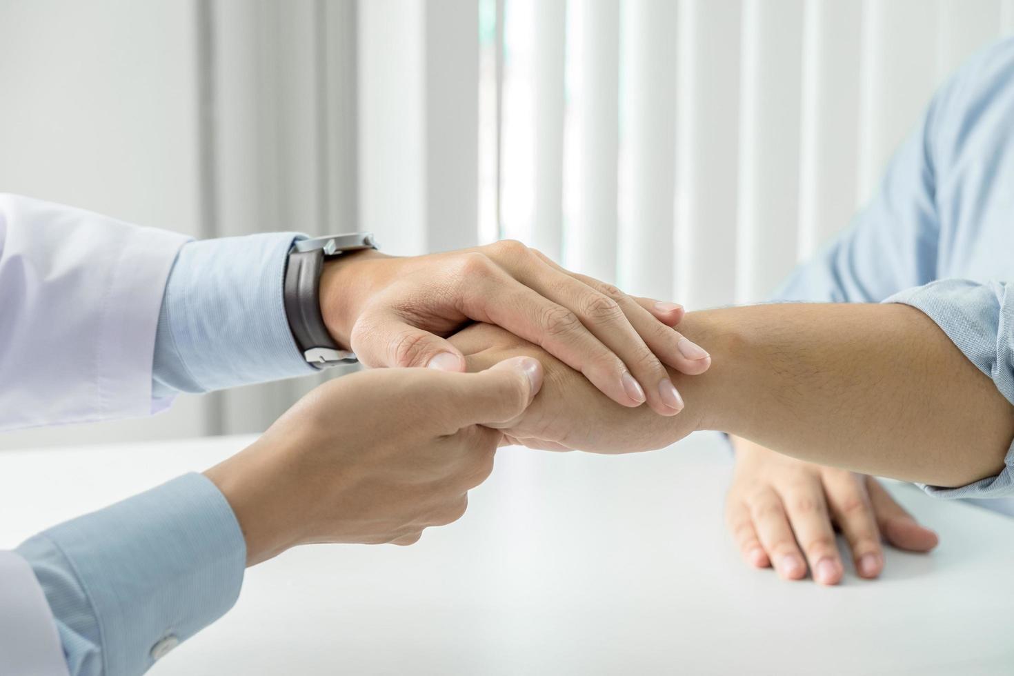 Close up of doctor touching patient hand for support photo