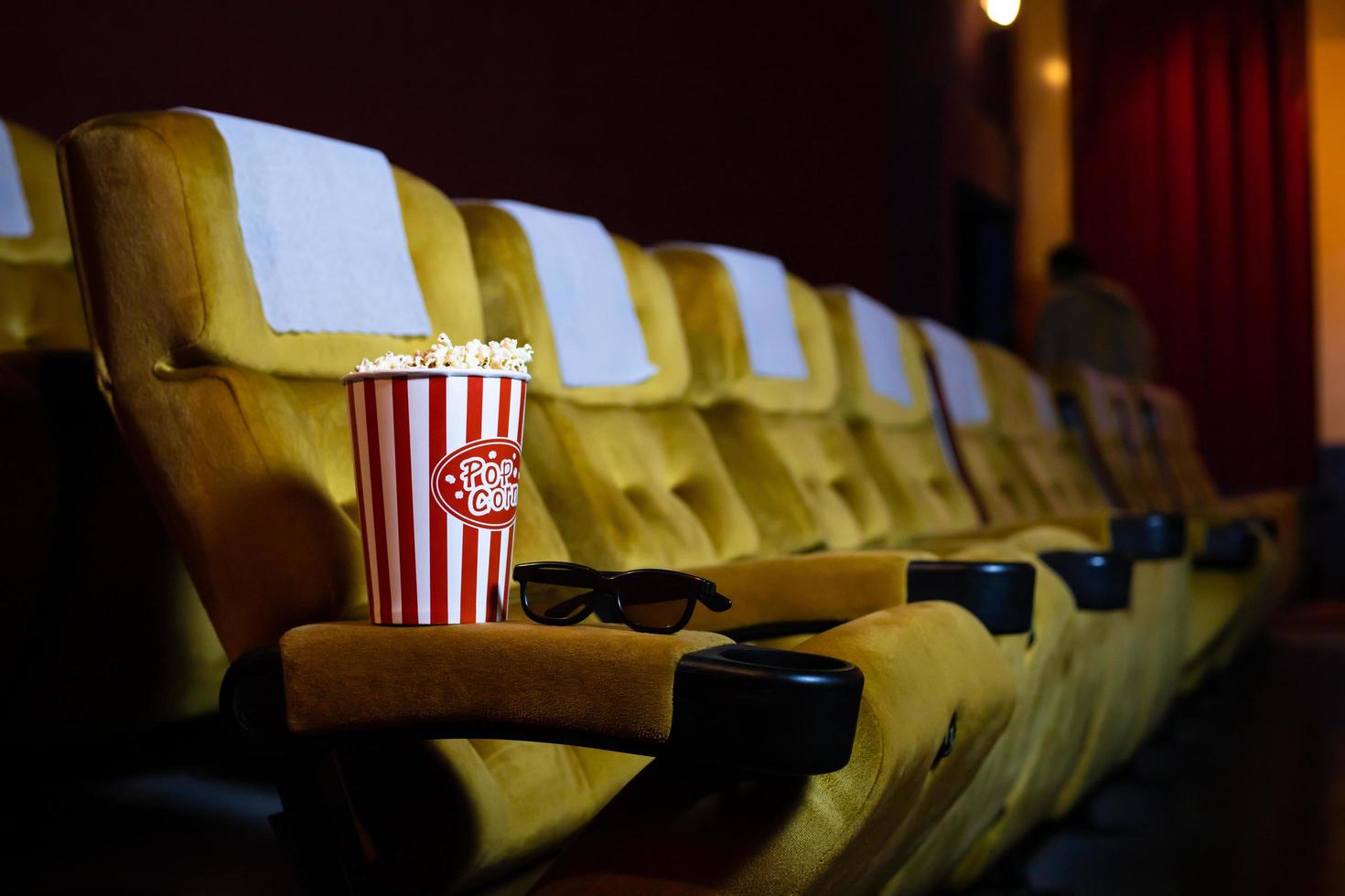 Popcorn and glasses on a seat in a theater  photo
