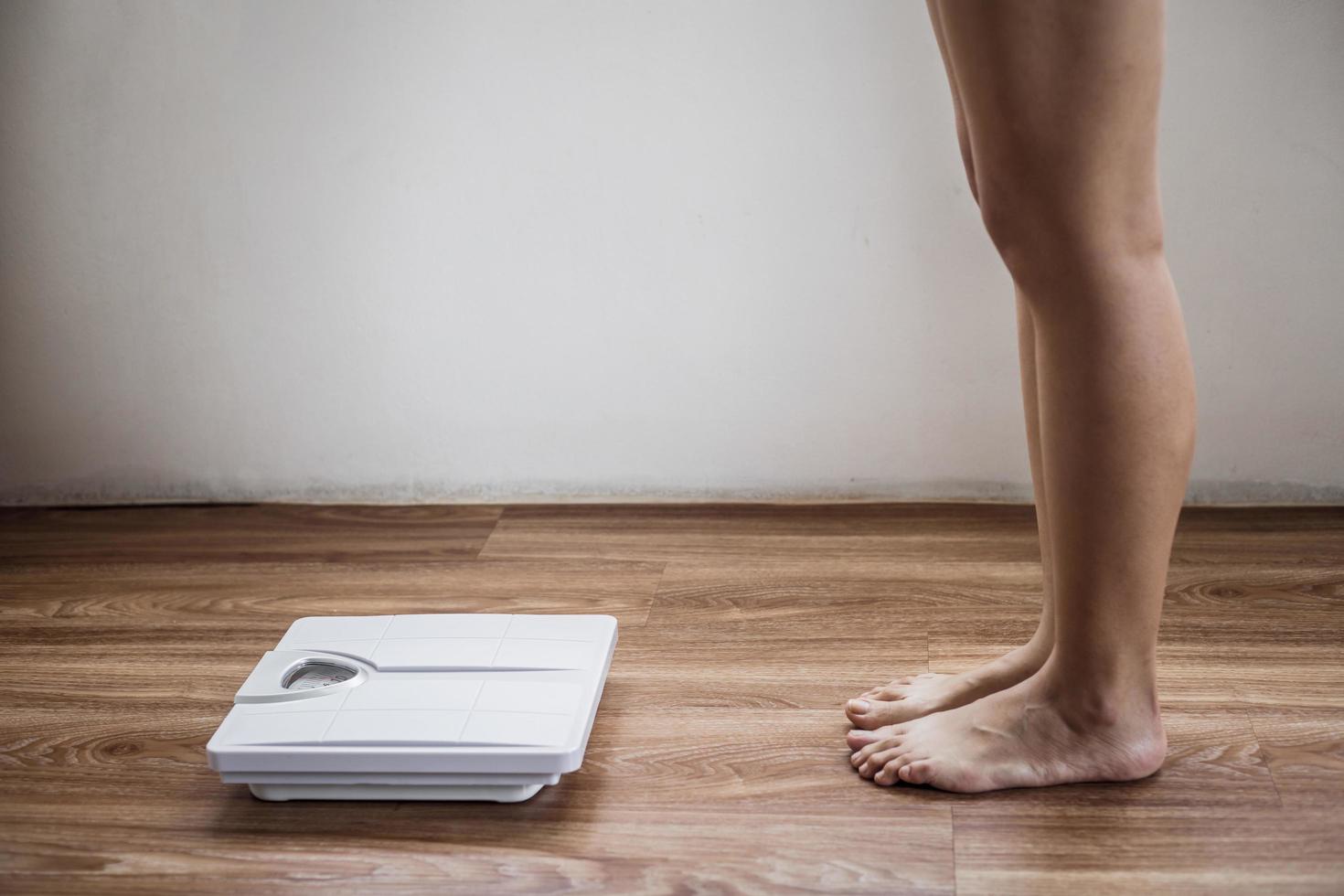 Female bare feet approaches scale photo