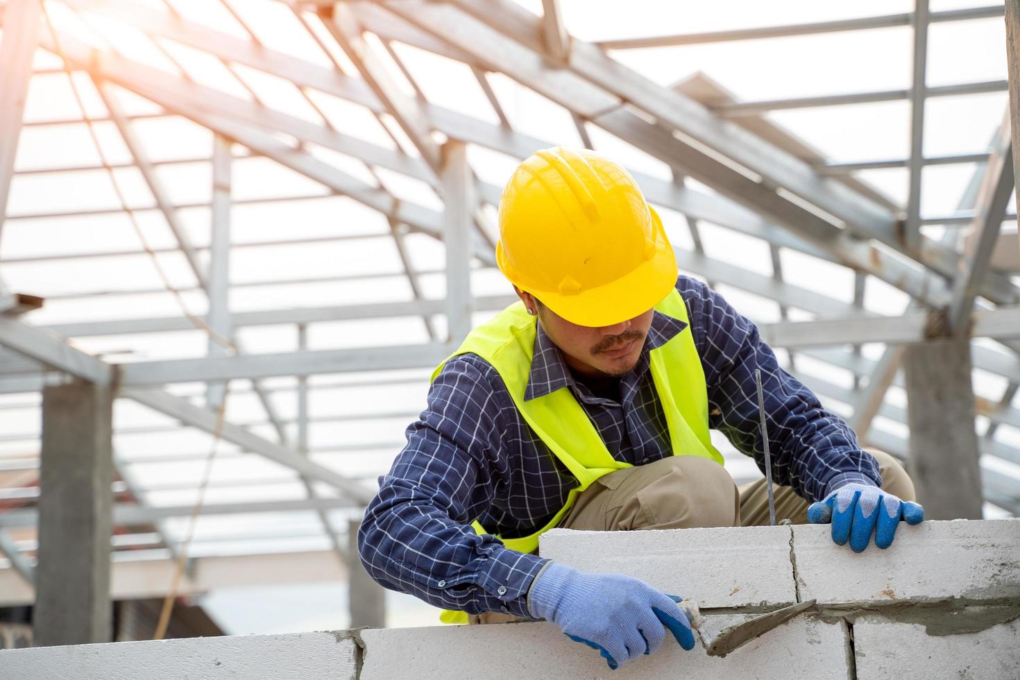 Builder is applying plaster to a brick wall photo