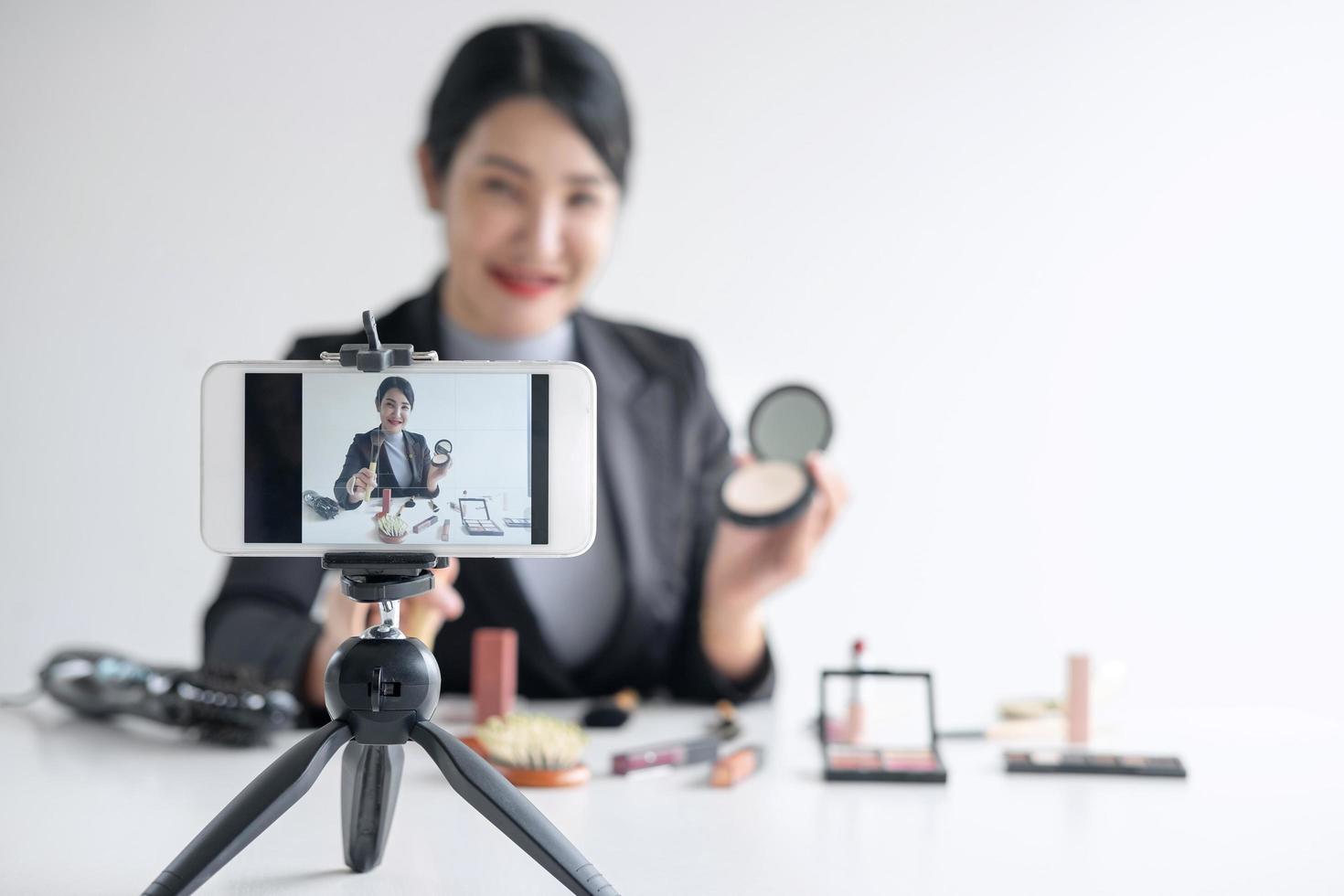 vlogger mujer está haciendo un tutorial de maquillaje foto