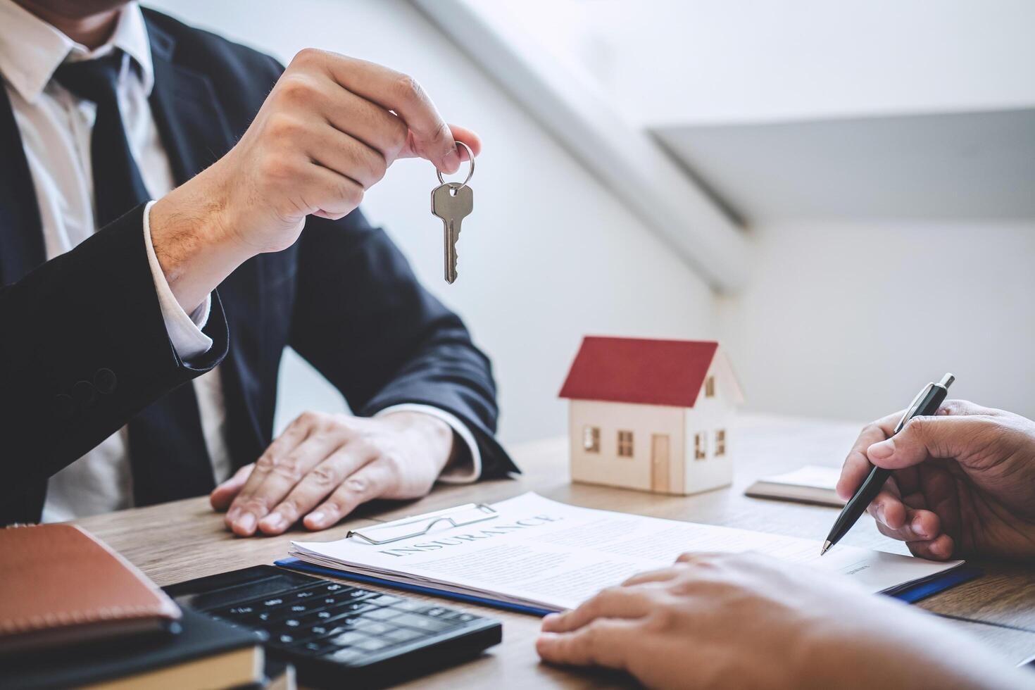 Estate agent giving house keys to client photo