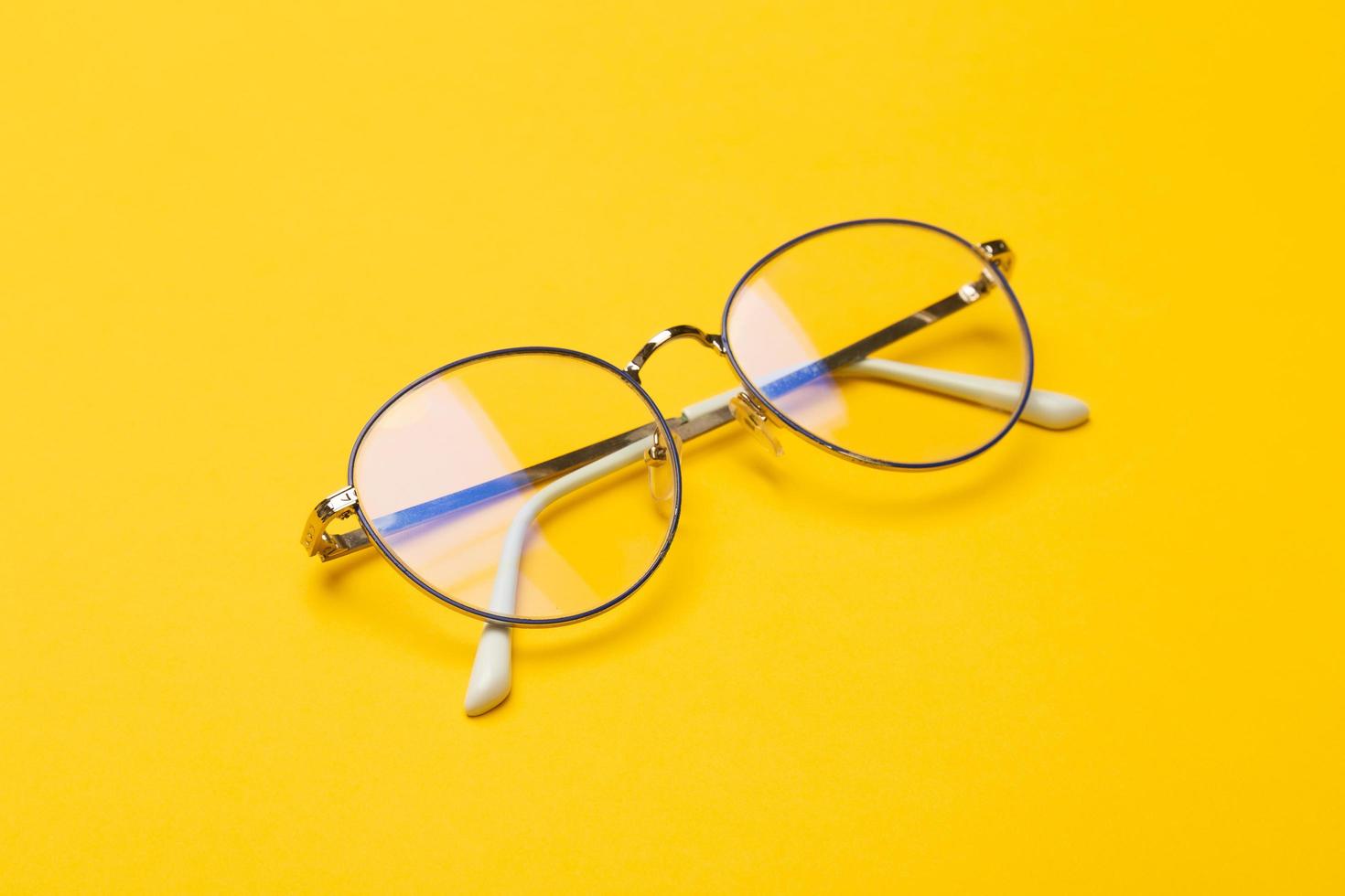Pair of glasses on yellow background photo