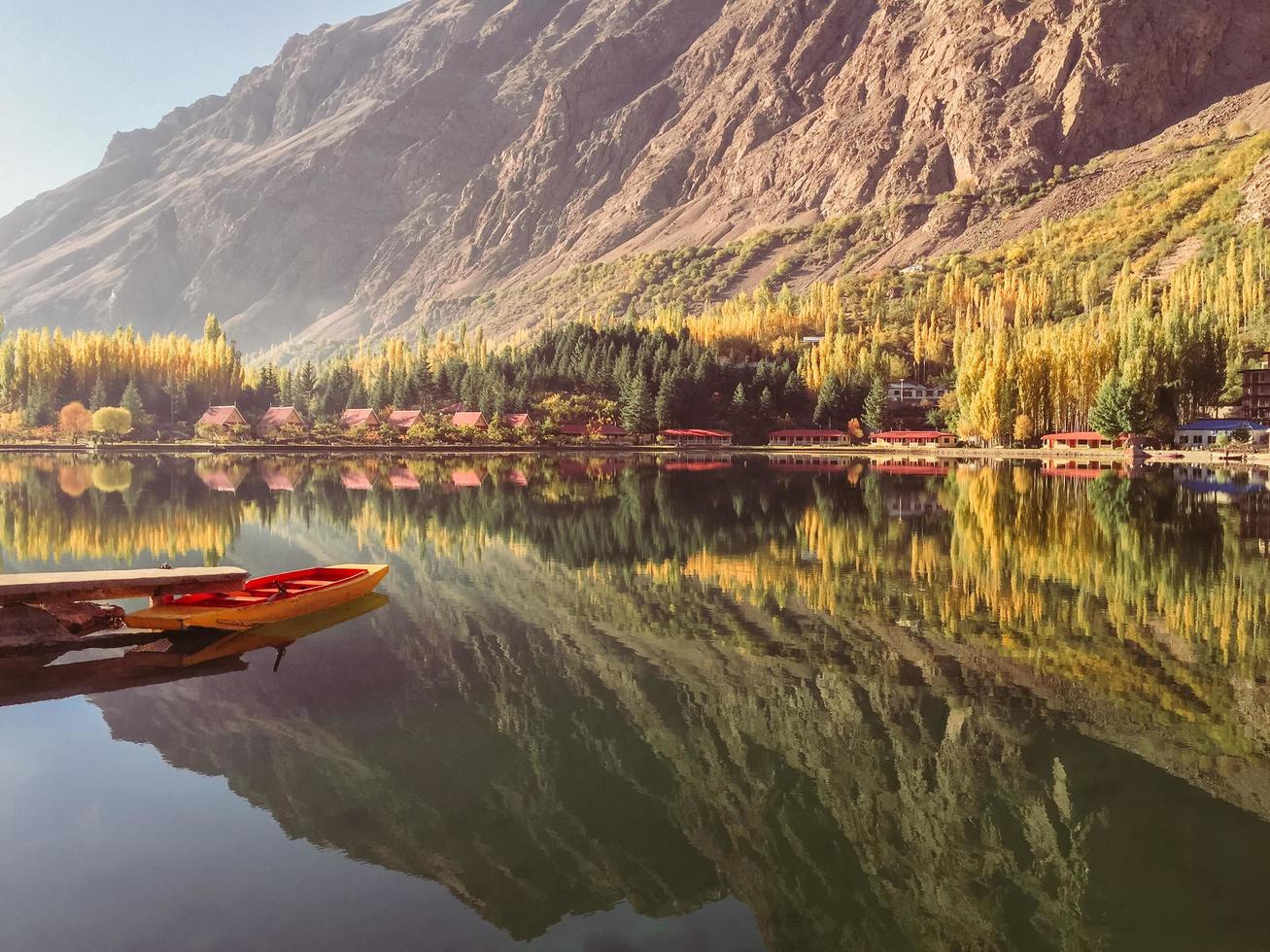 View of docked boat on still water with mountains in background photo