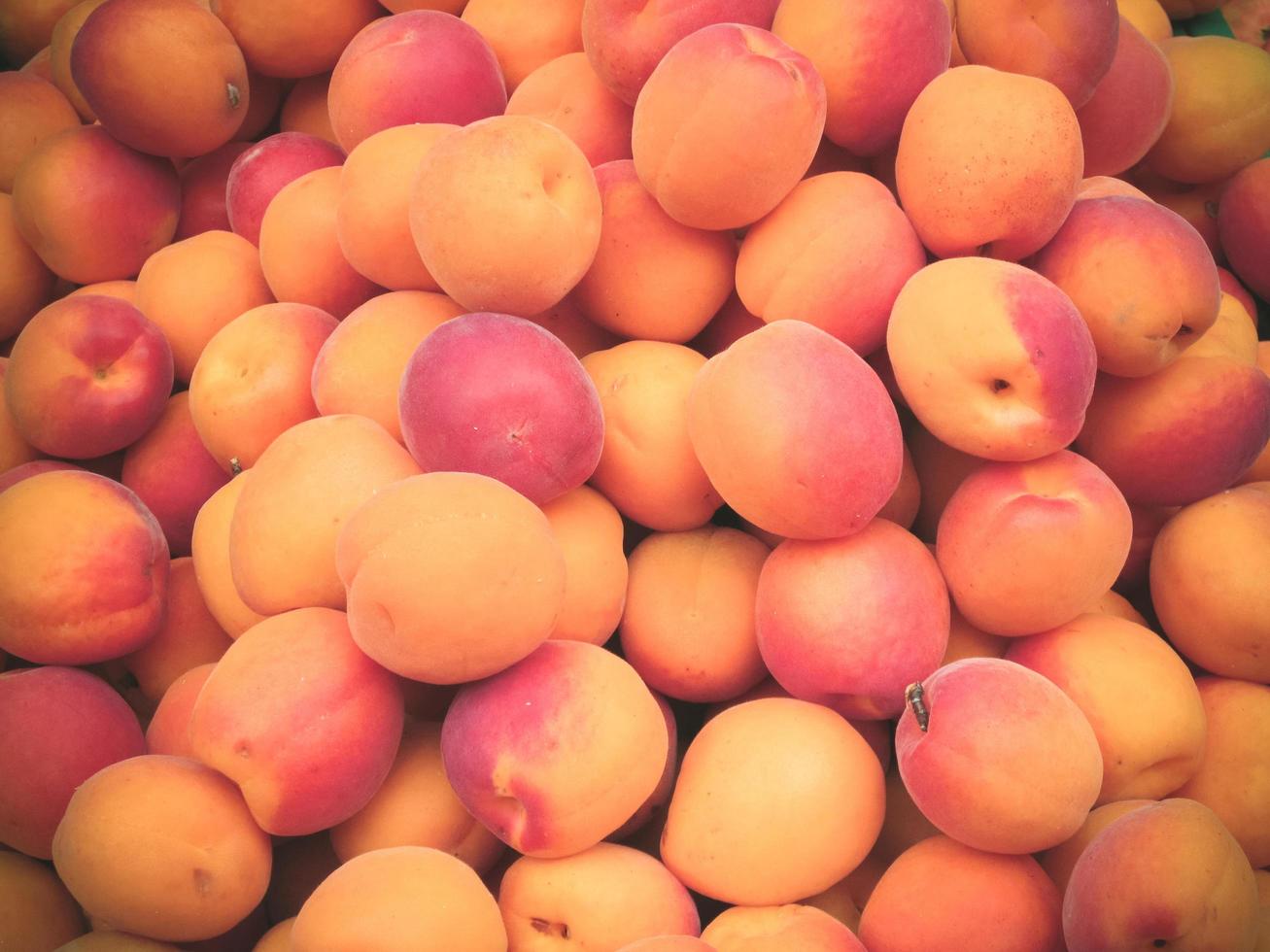 Montón de duraznos maduros frescos para la venta en el mercado. foto