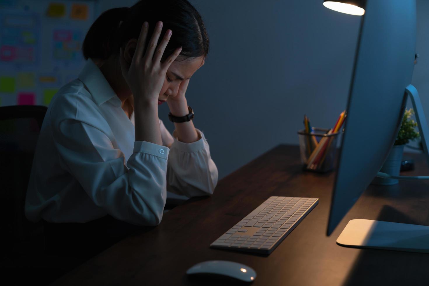 mujer estresada trabajando hasta altas horas de la noche foto