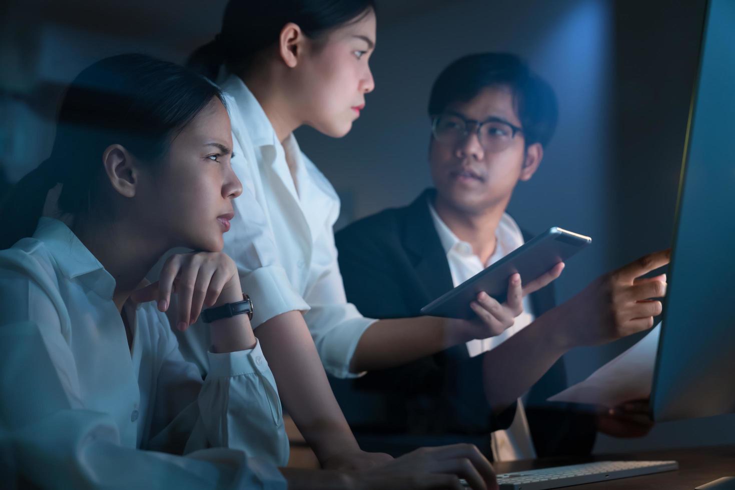 Coworkers working in office late at night photo