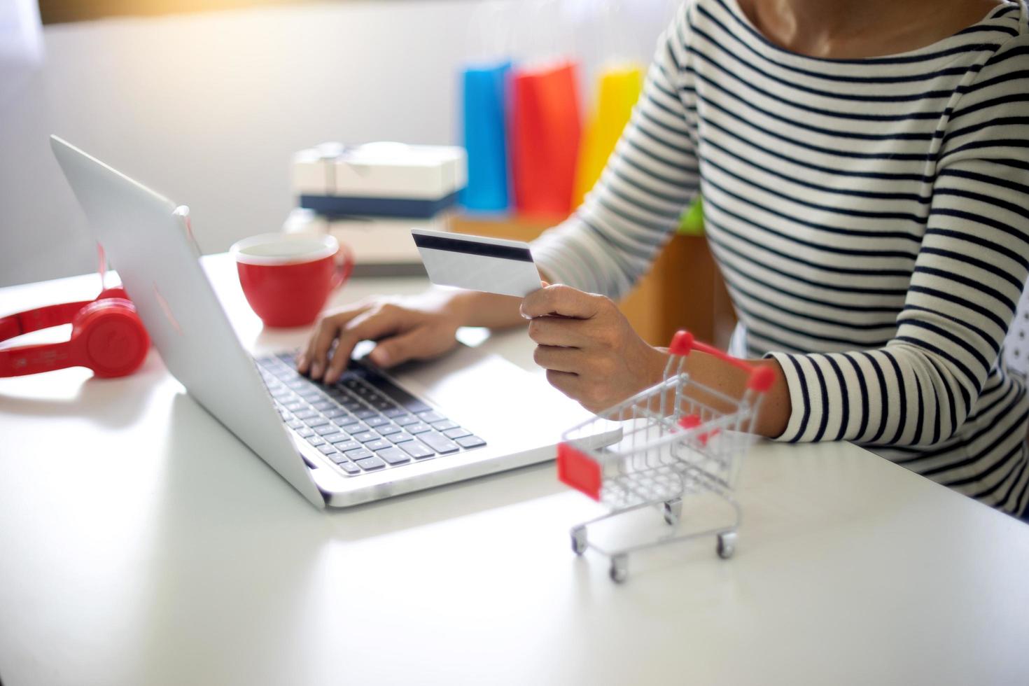 mujer sentada en la computadora de compras en línea foto