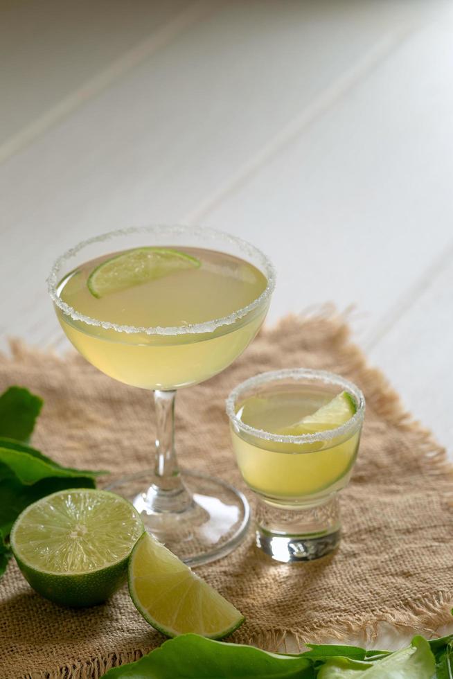 Mixed cocktail beverage against squeezed limes photo