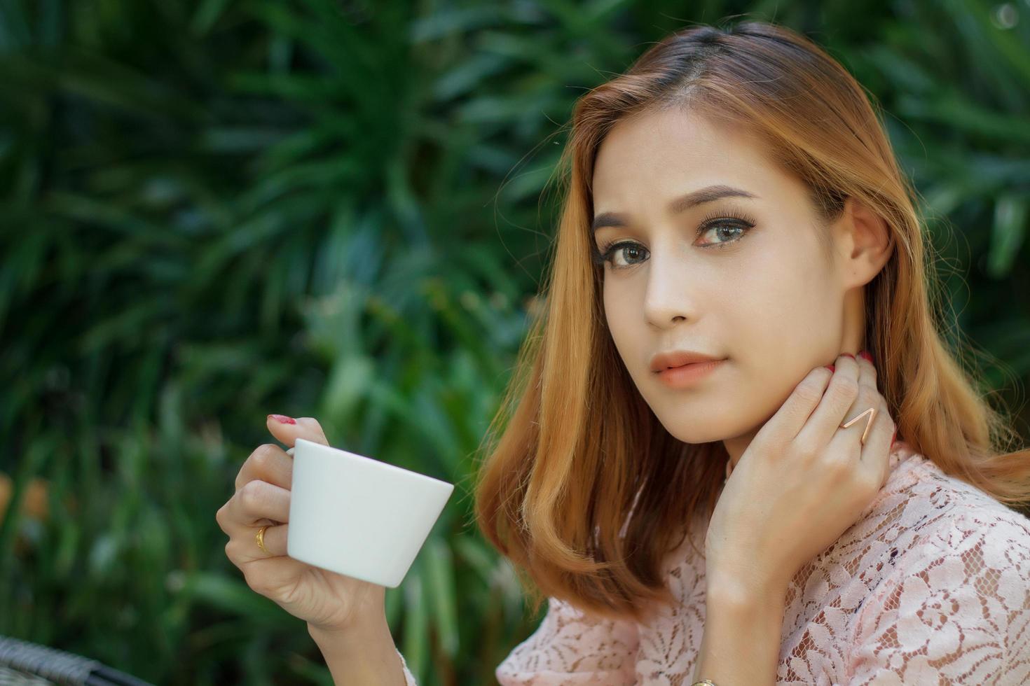 mujer tomando café afuera foto