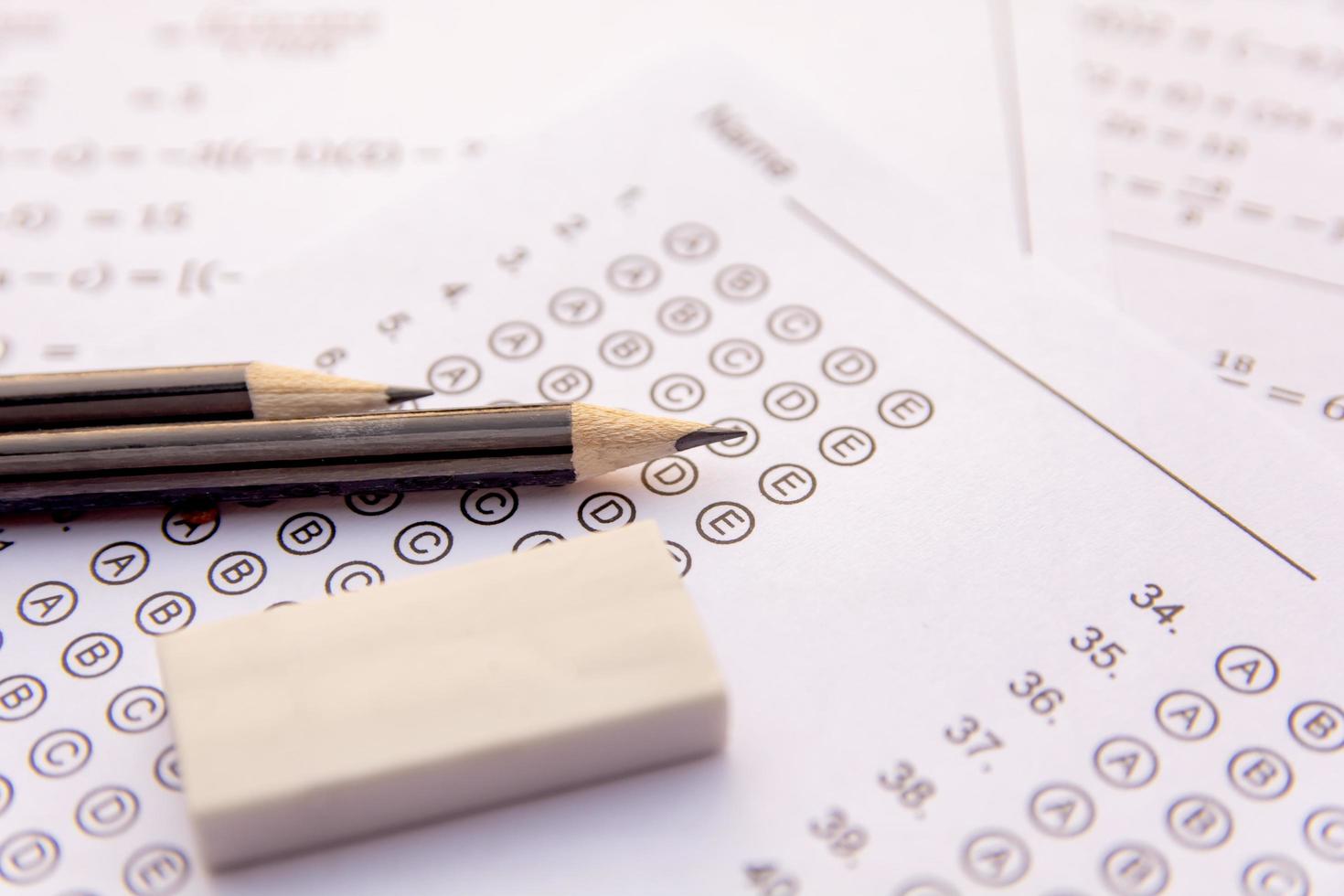 Close-up of pencils and eraser on test sheets photo