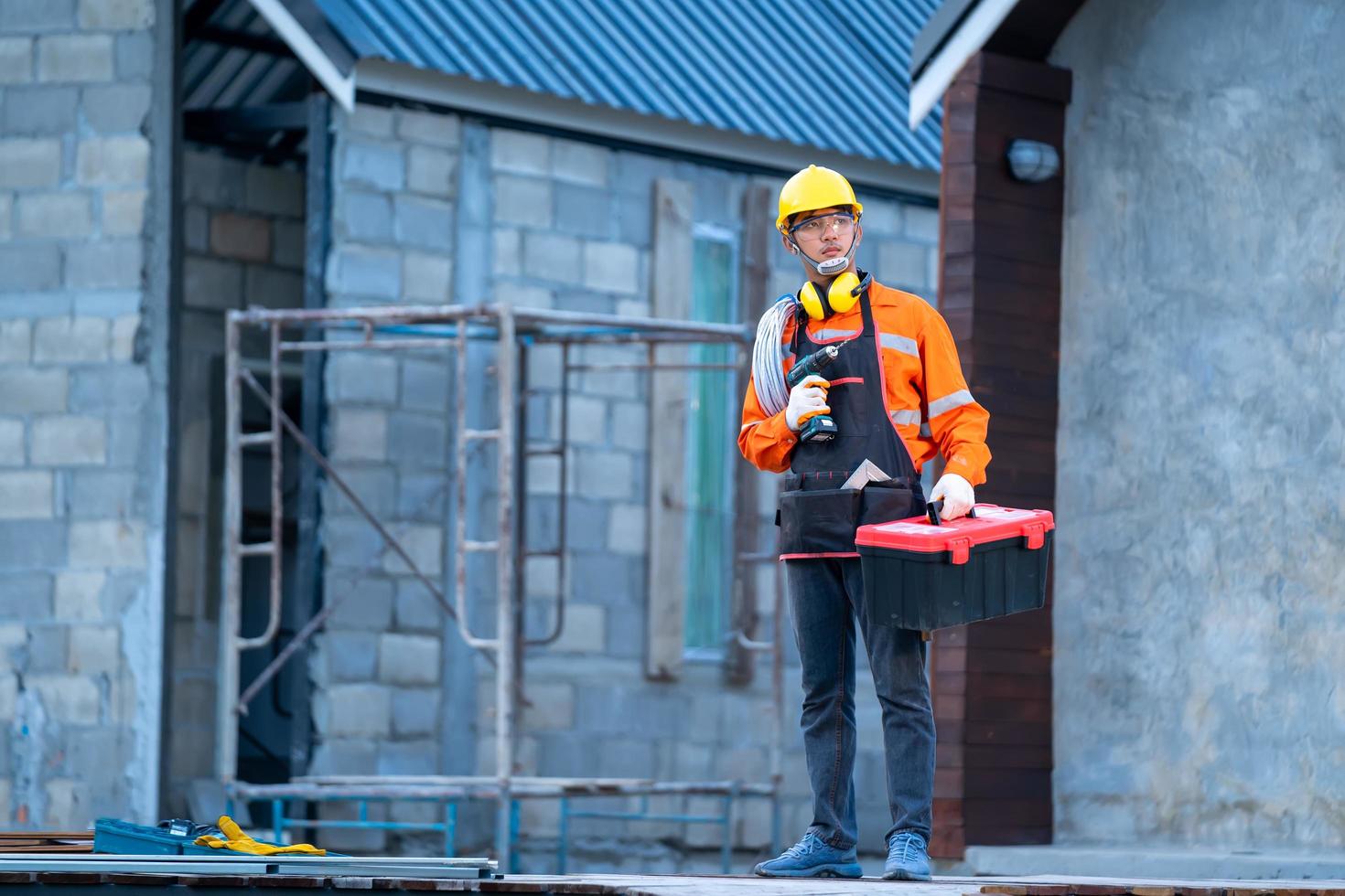 trabajador de la construcción con taladro y caja de herramientas foto