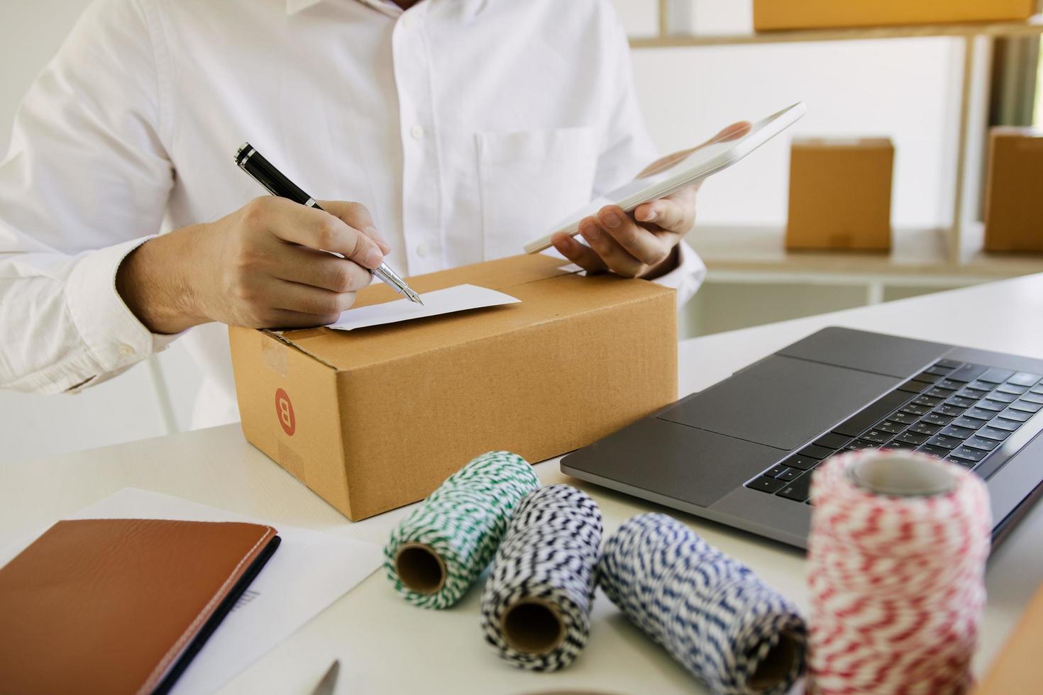 Young male preparing package at post office photo