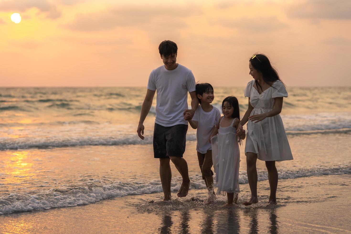 familia asiática disfruta de vacaciones en la playa foto