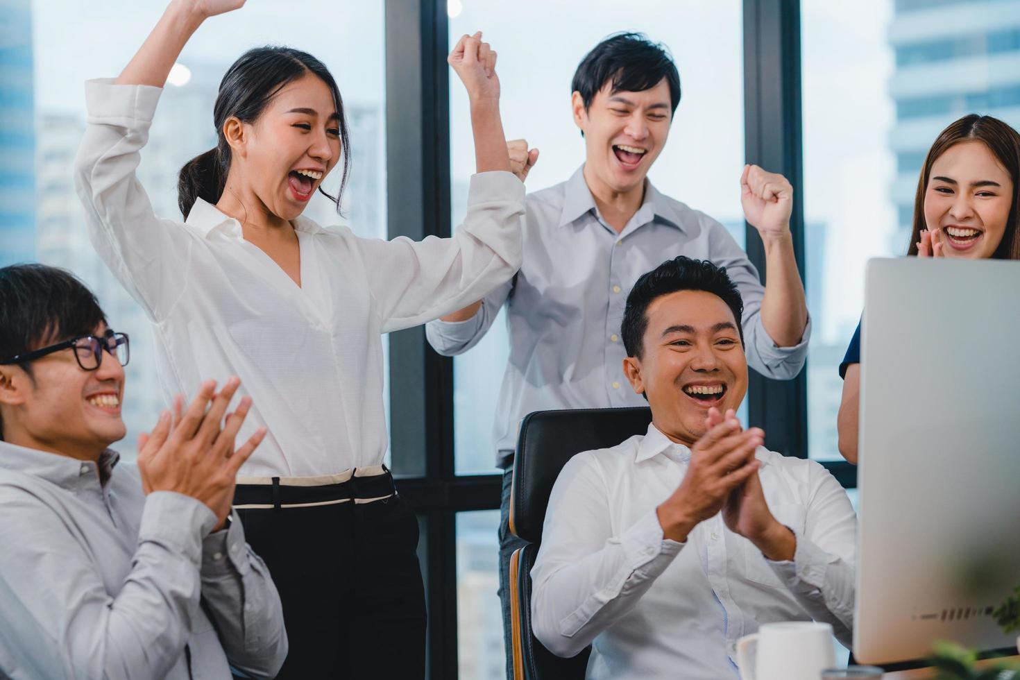 Group of young businesspeople celebrate in the office photo