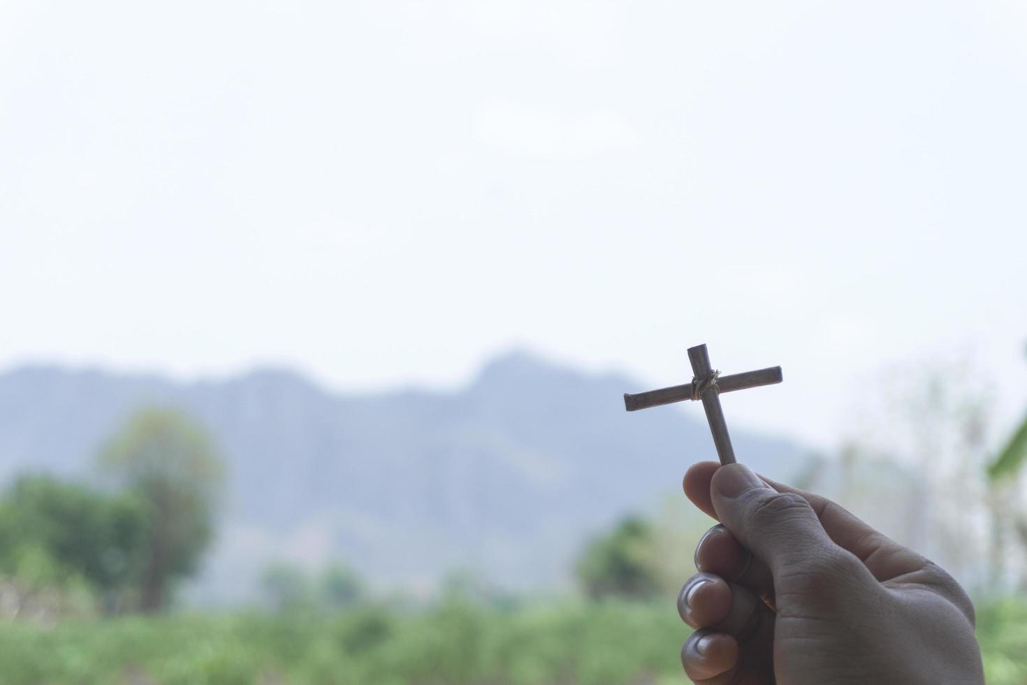 Homemade cross with mountains in background photo