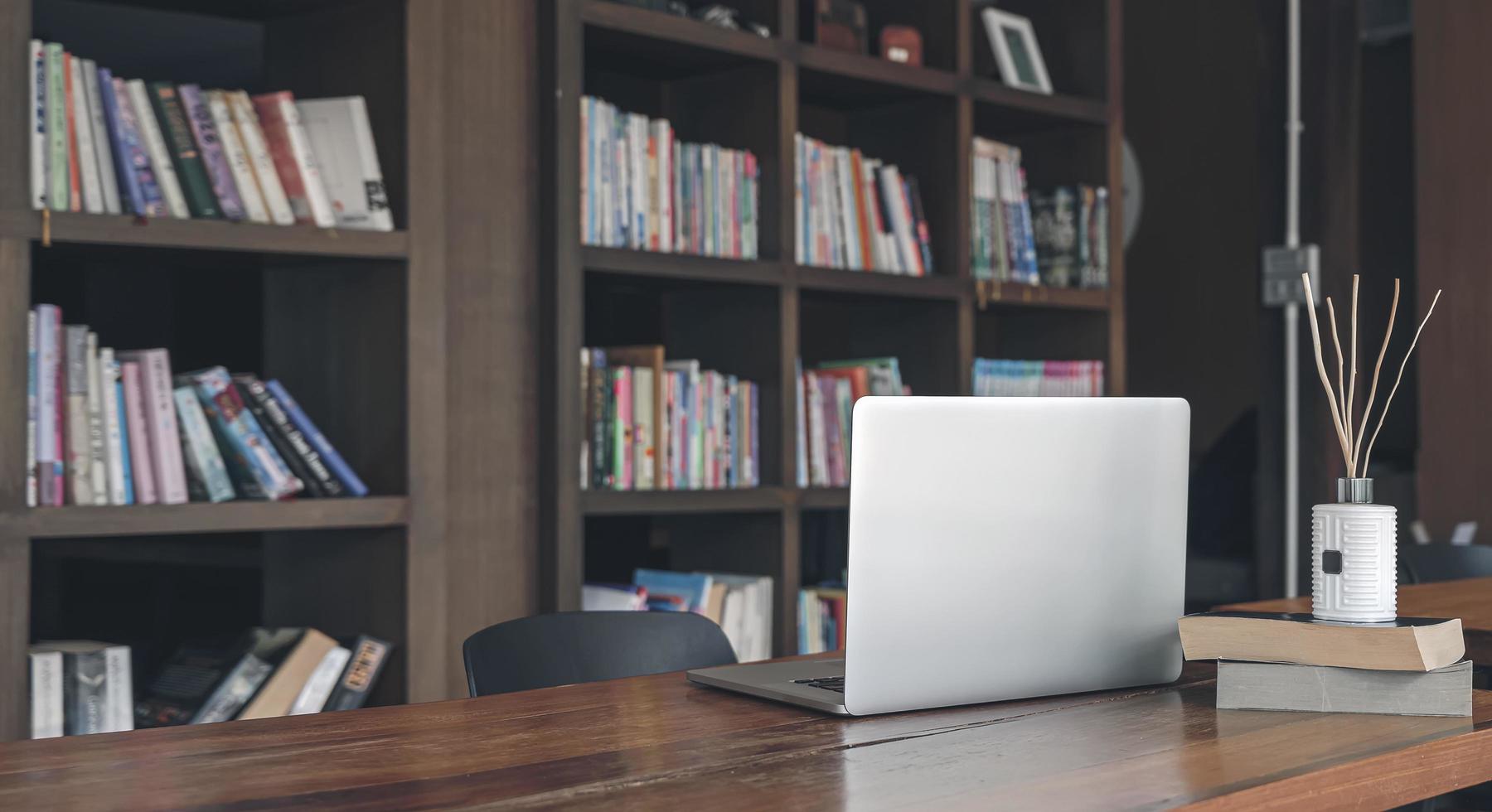 Lifestyle office setting with laptop and bookshelf  photo