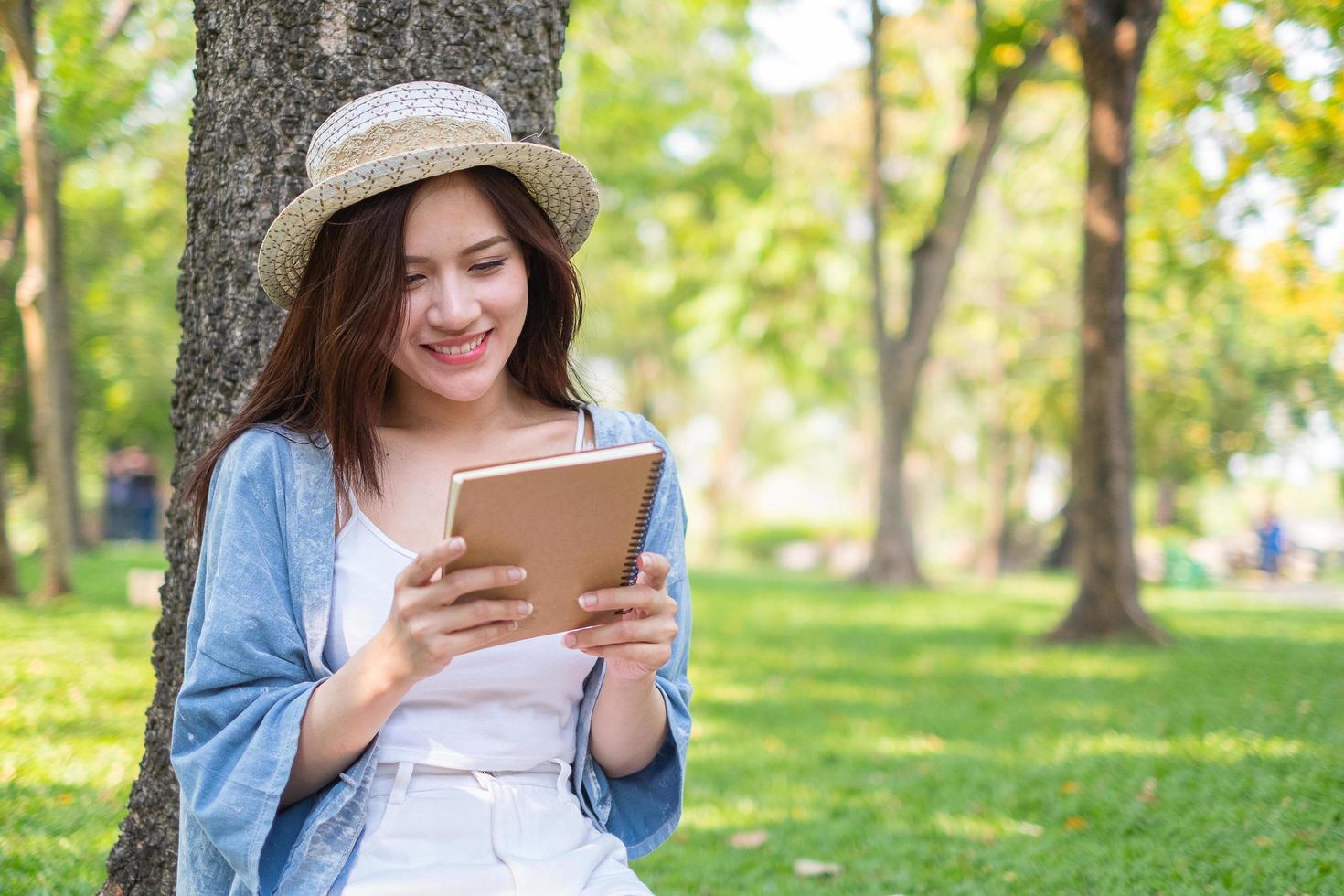 Woman looking at notebook in park photo