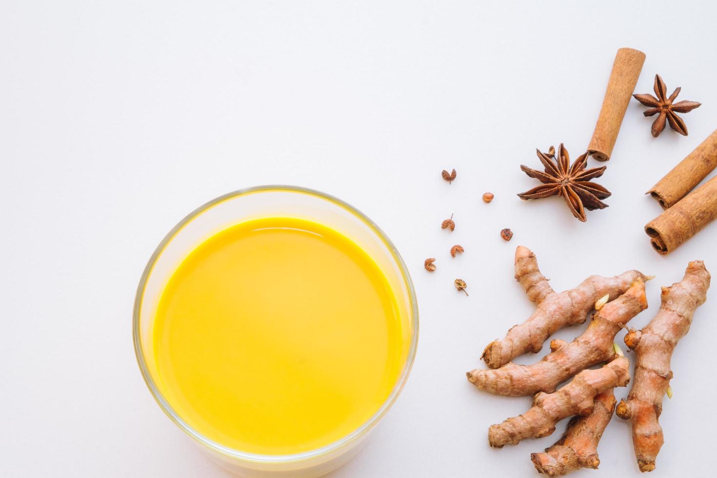 Golden milk turmeric latte with spices on white background photo