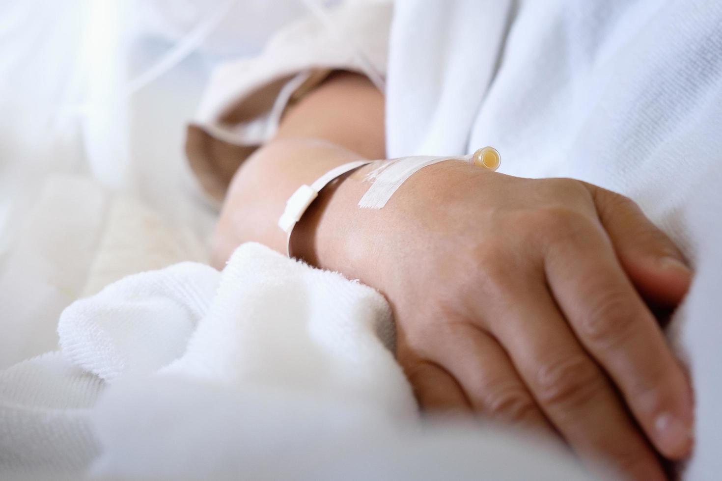 Closeup of intravenous tube on patient's hand photo