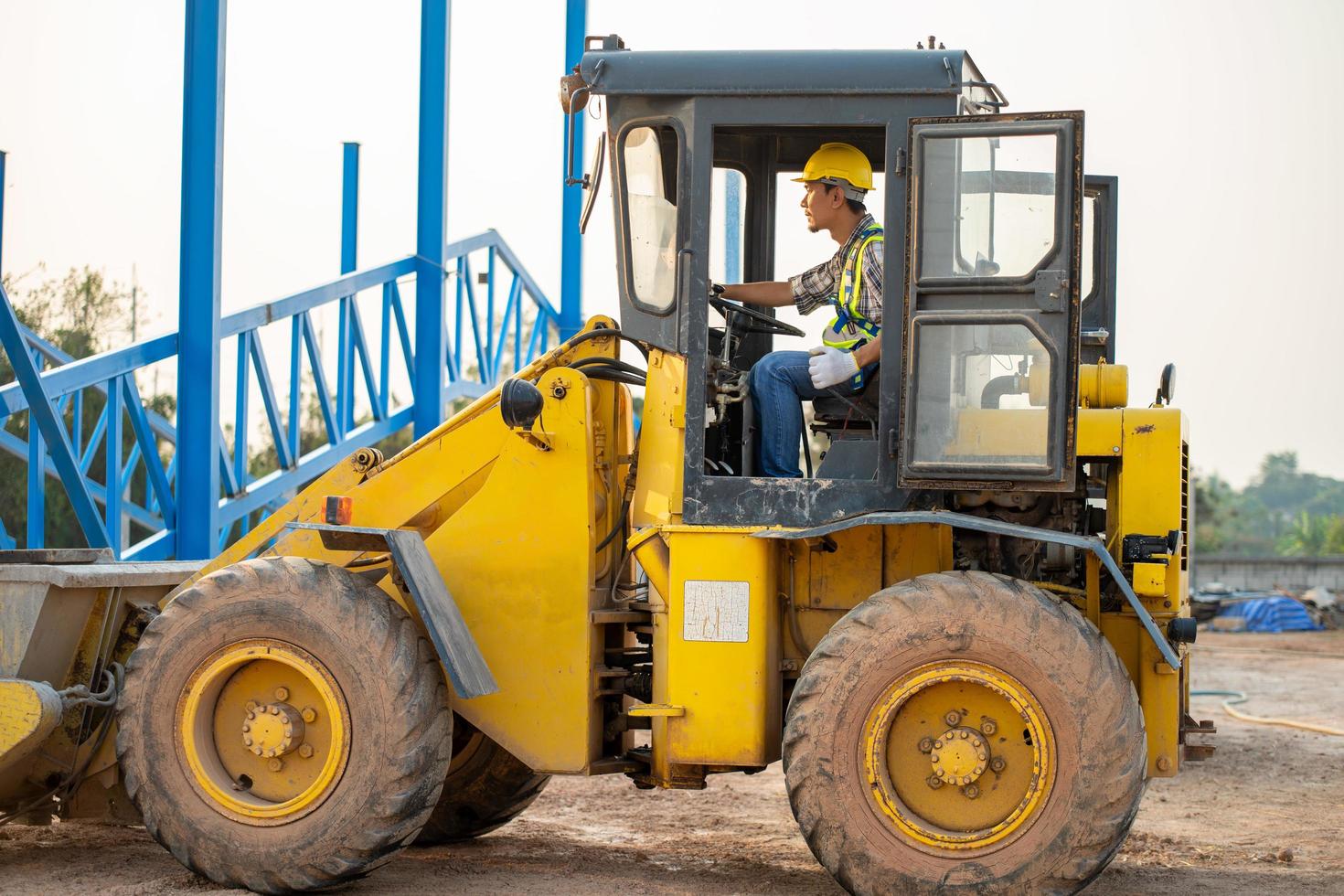 Construction worker driving backhoe loader photo