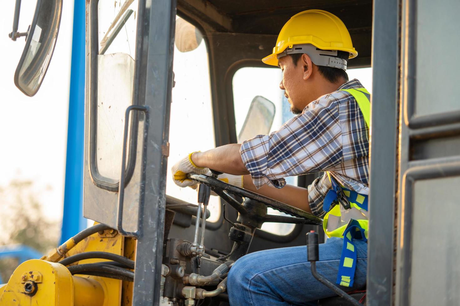 Construction worker driving backhoe loader photo